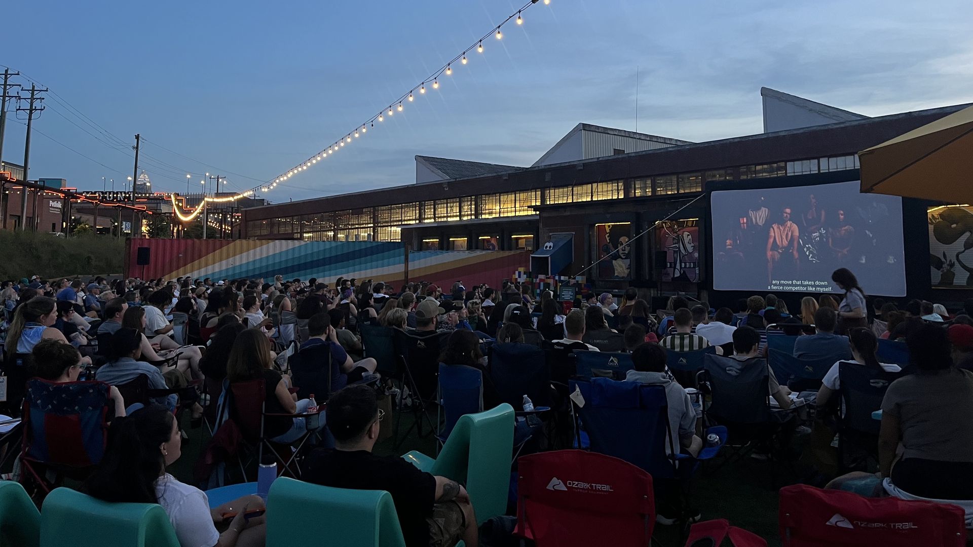 people watching a large screen outside