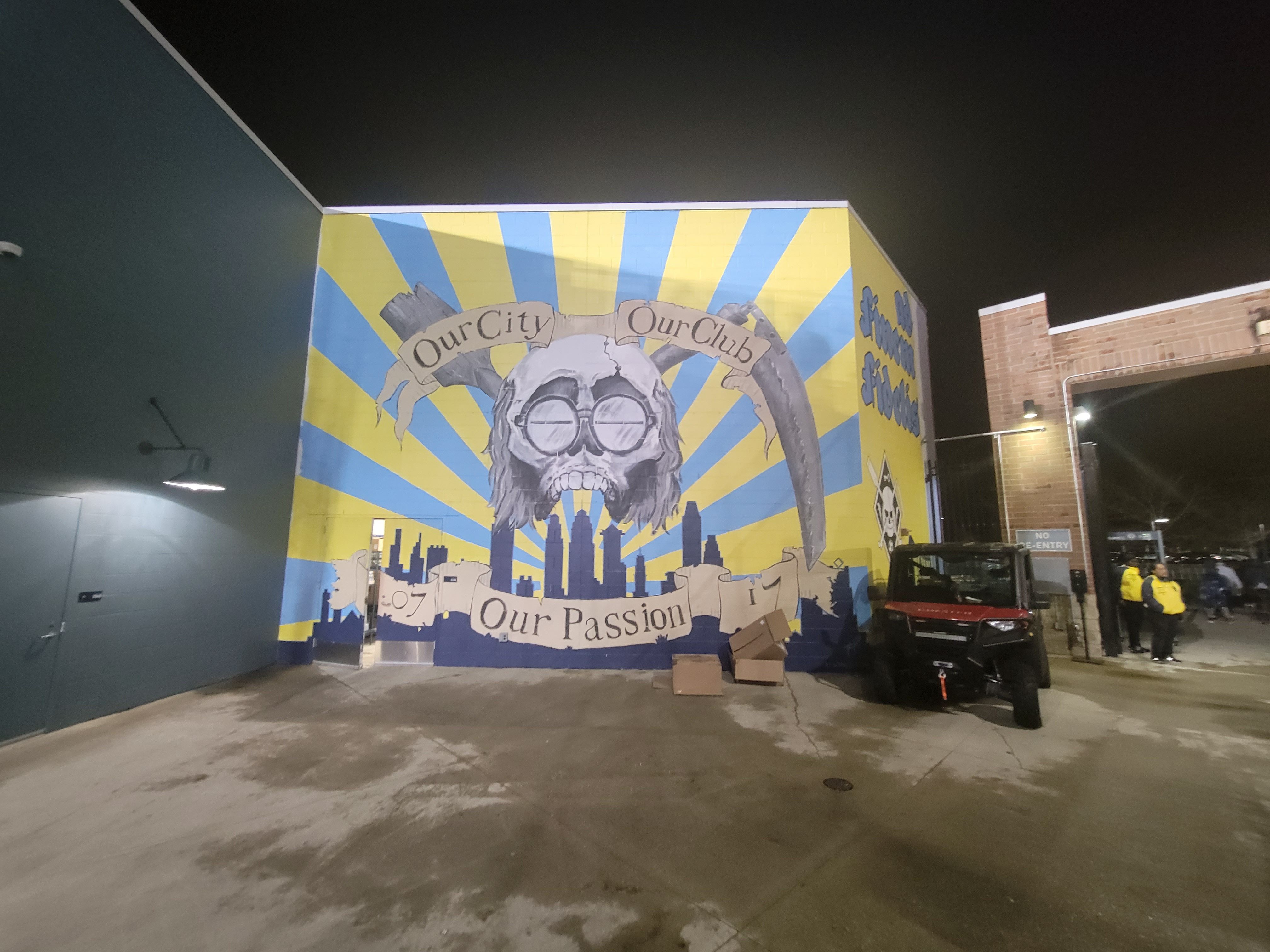A mural with images of a skull with glasses and a scythe above the Philly skyline, and the motto: "Our city. Our club. Our passion."