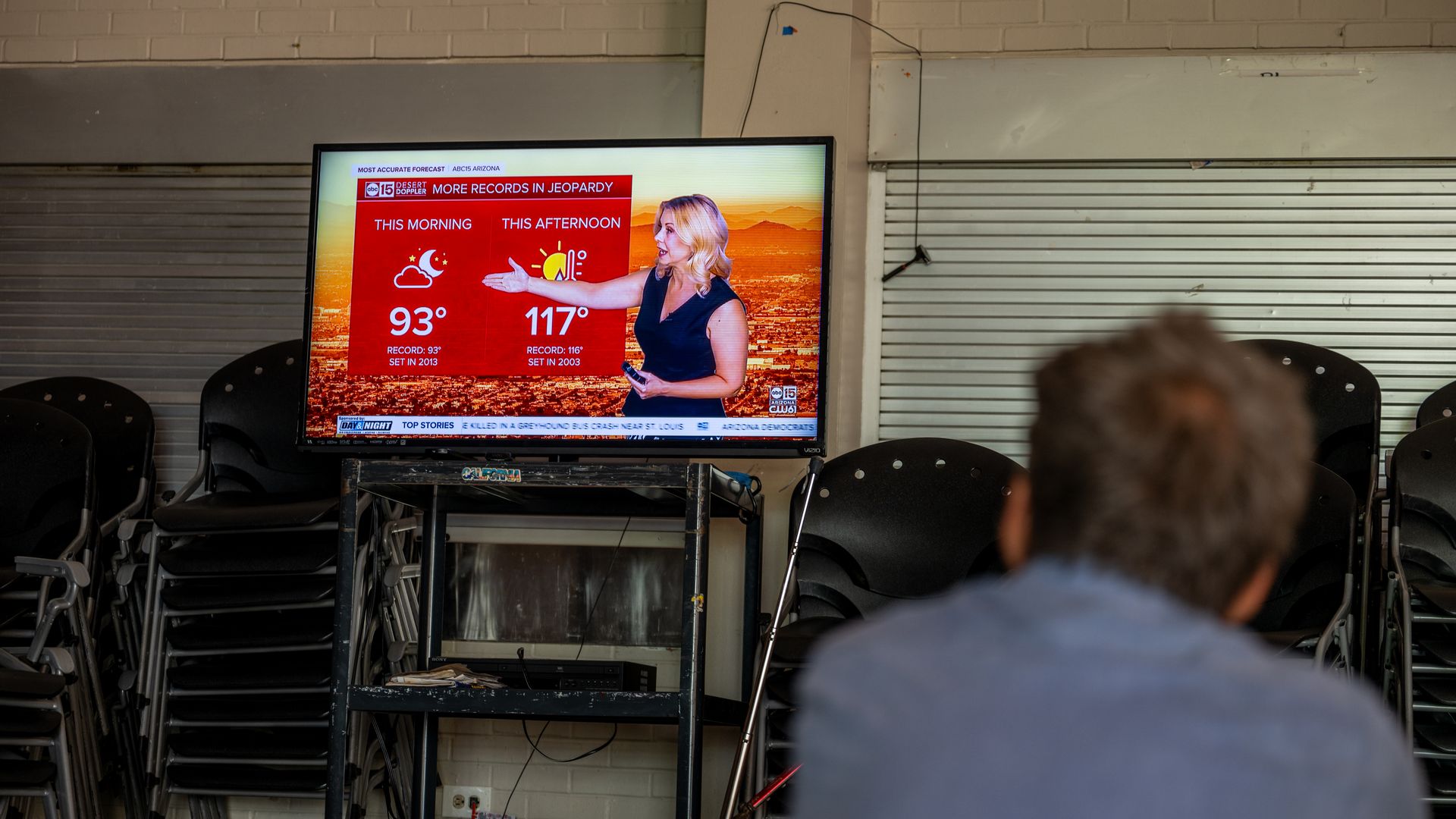 A person watches a television weather forecast during a heat wave from a cooling center in Phoenix on July 14.
