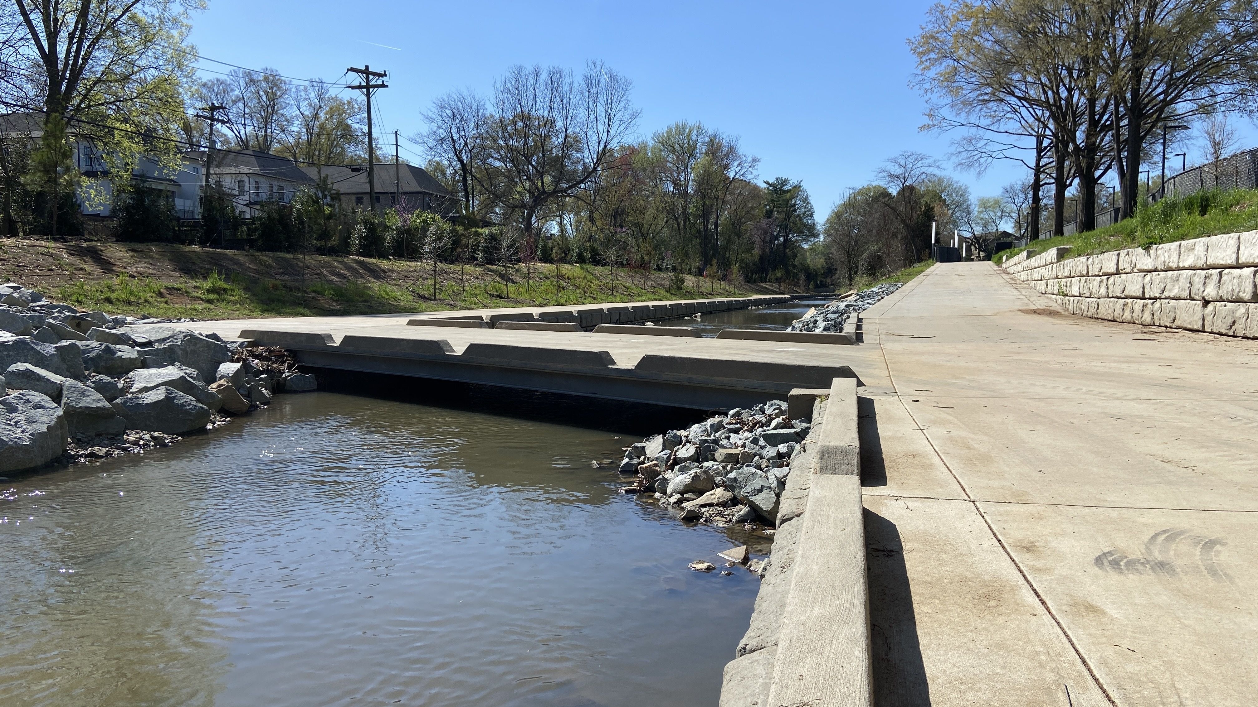 A small concrete bridge goes over the creek by Atrium Health