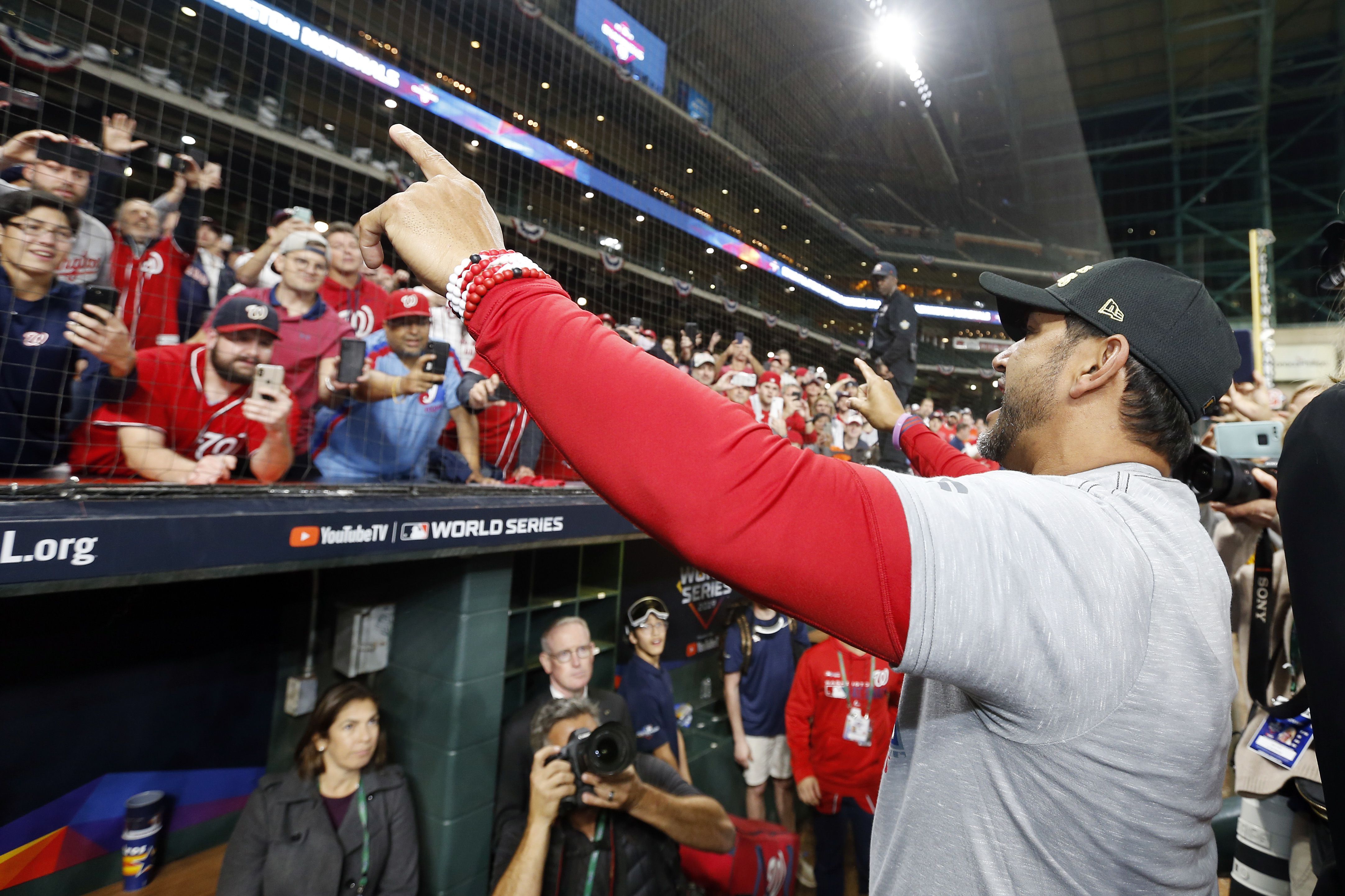 Nationals manager Dave Martinez celebrates with fans. 