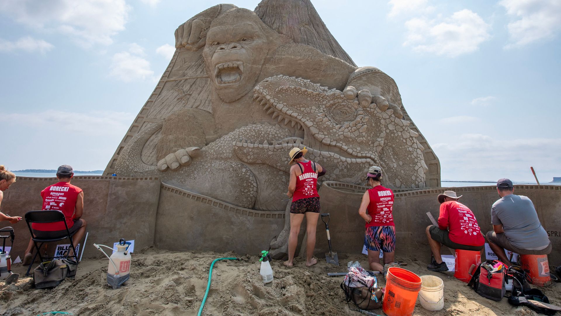 Six people are putting the finishing touches on a 22-foot King Kong sand sculpture on Revere Beach.