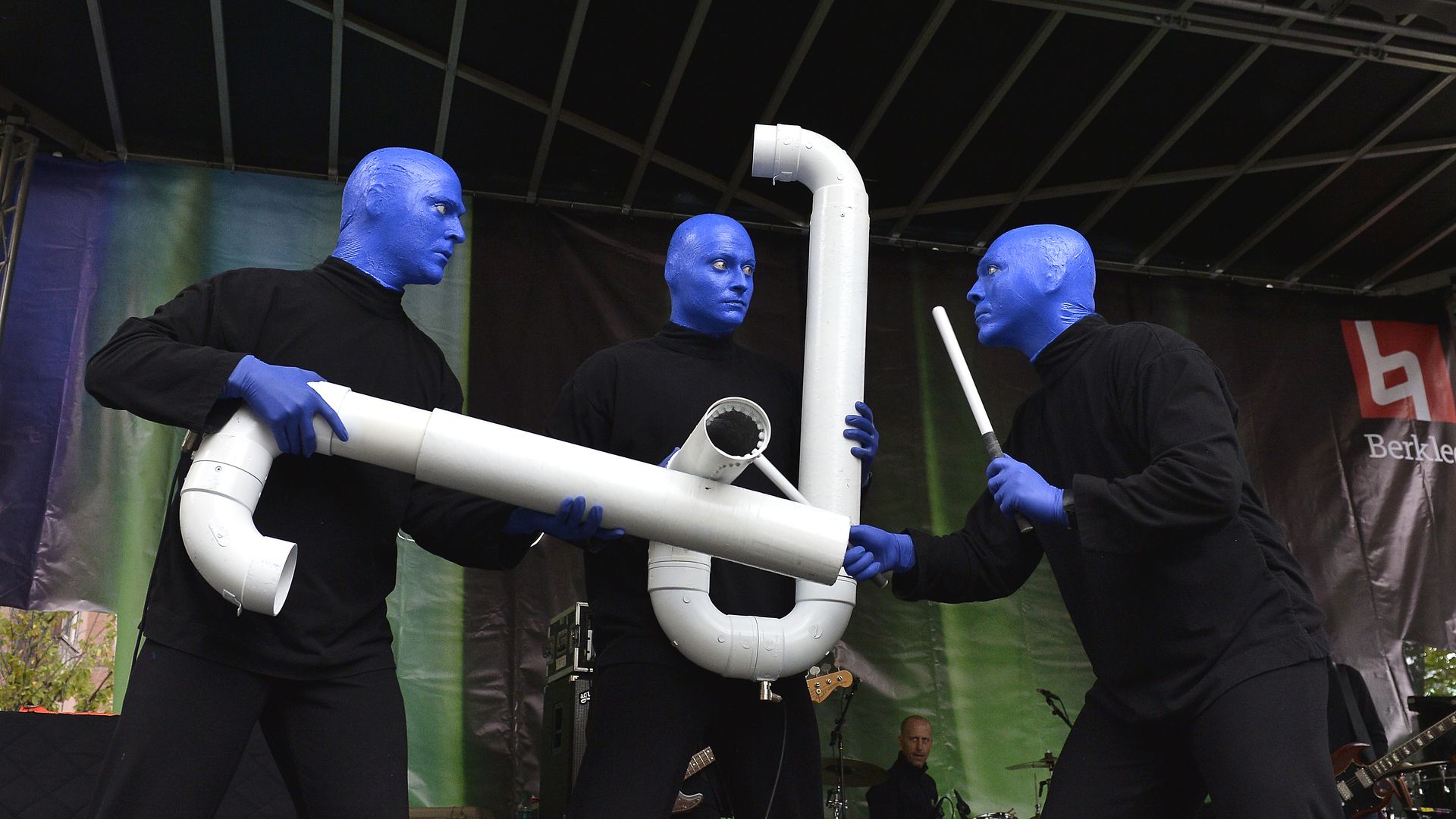 The three members of the Blue Man Group in Boston hold up large pipes, while one holds a stick,  at the 2017 Berklee Beantown Jazz Festival.