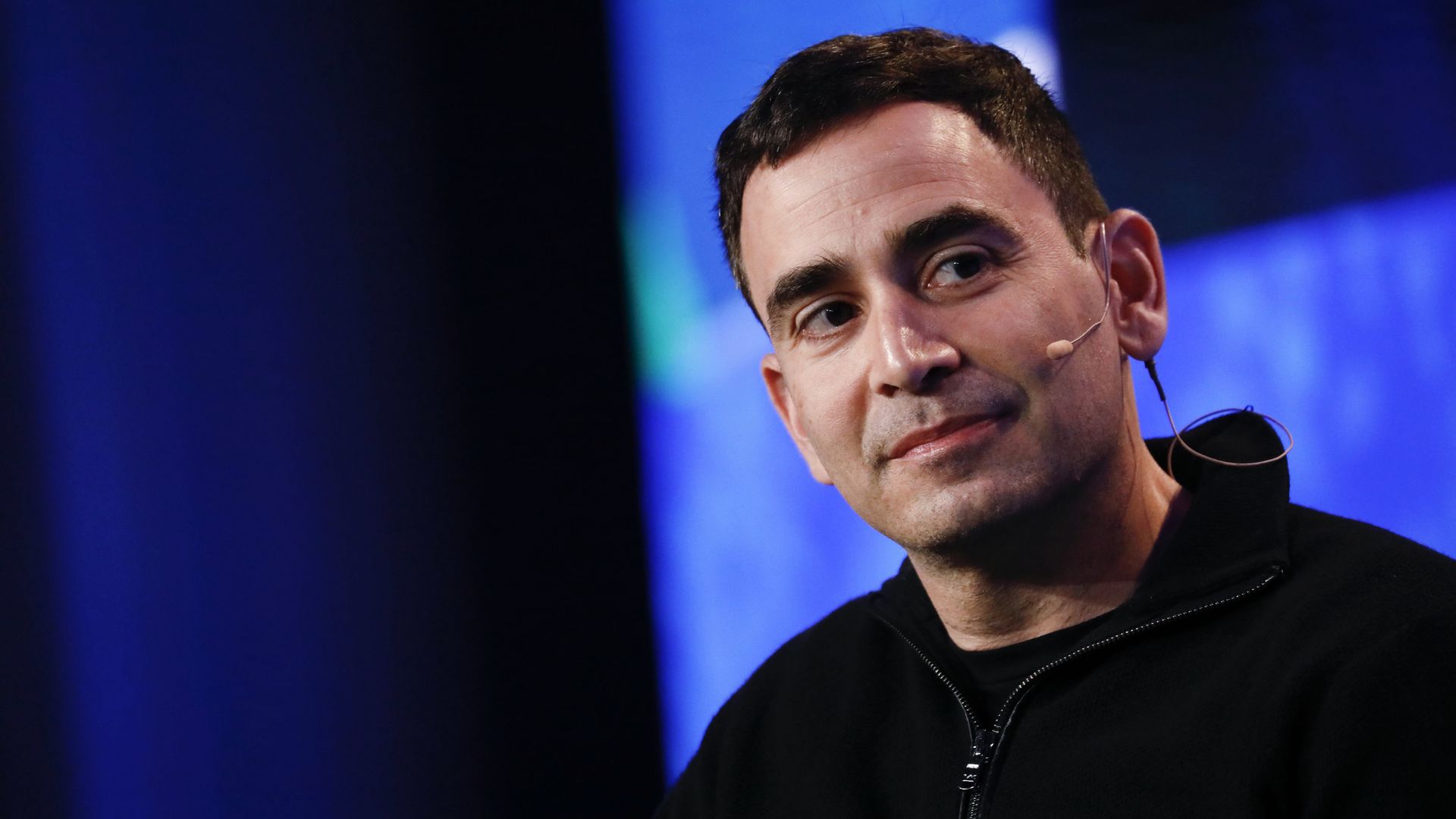Elad Gil listens on stage during a conference