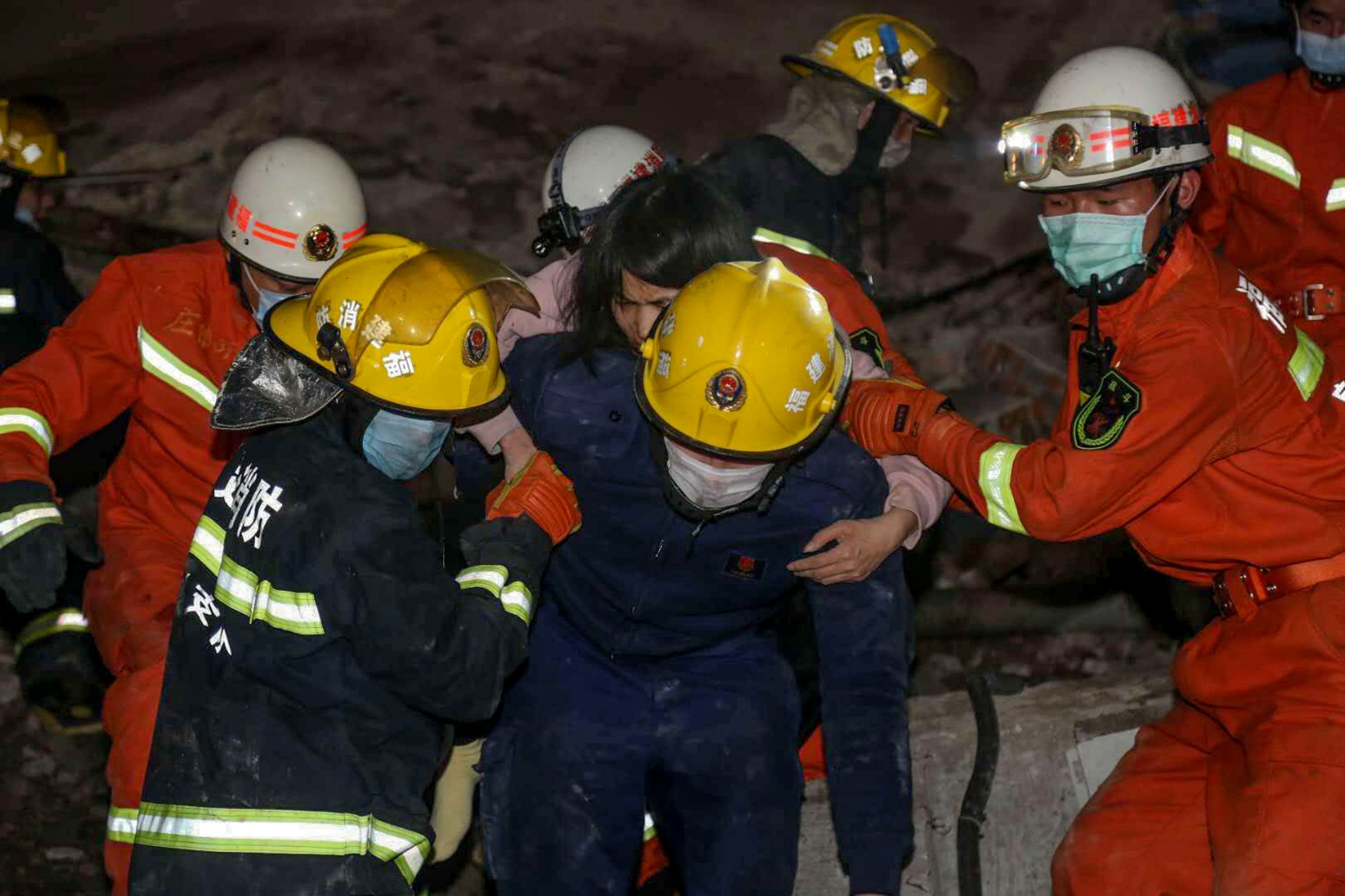 In this image, rescuers help a man walk