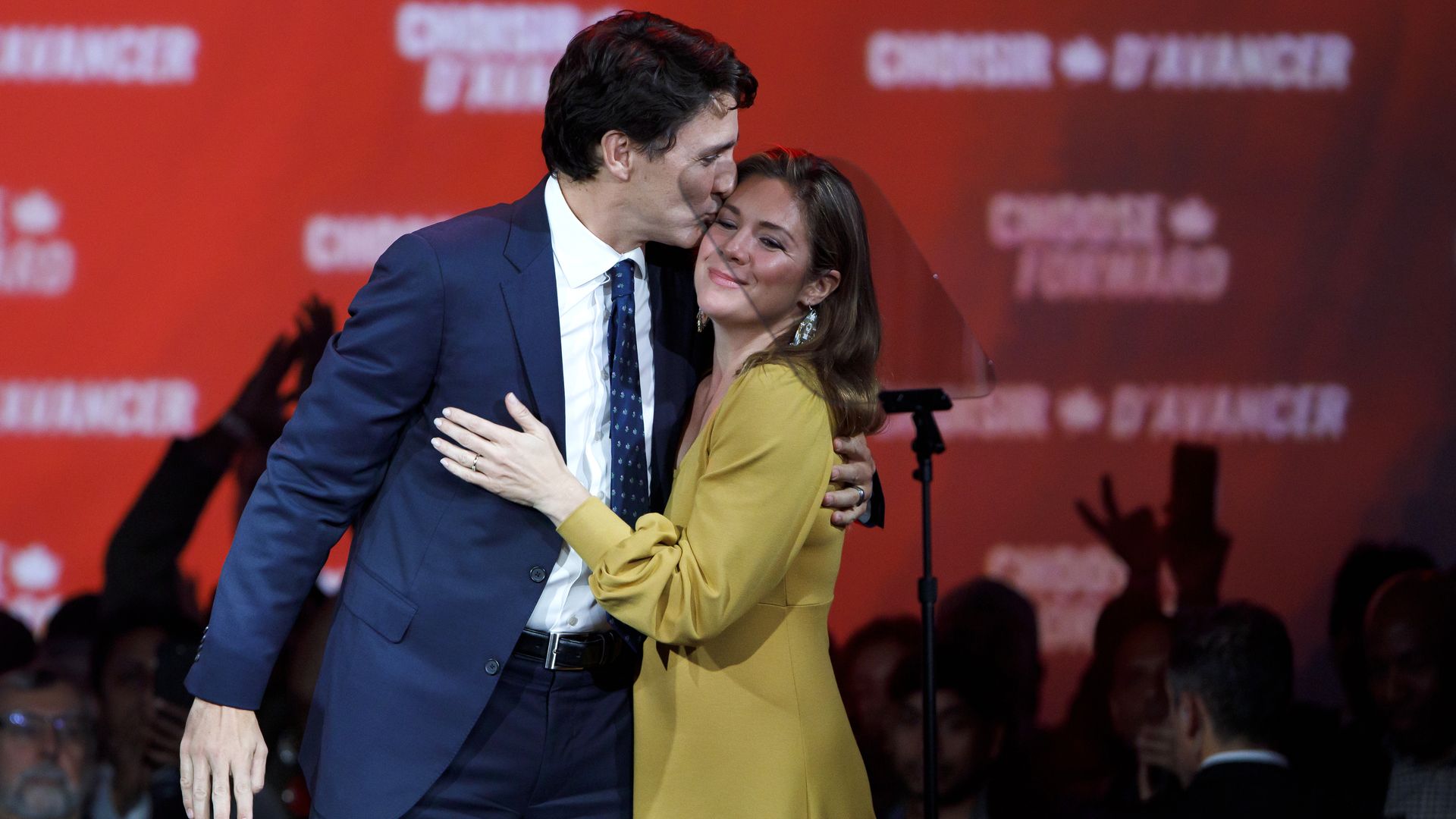 In this image, Trudeau and his wife stand and embrace