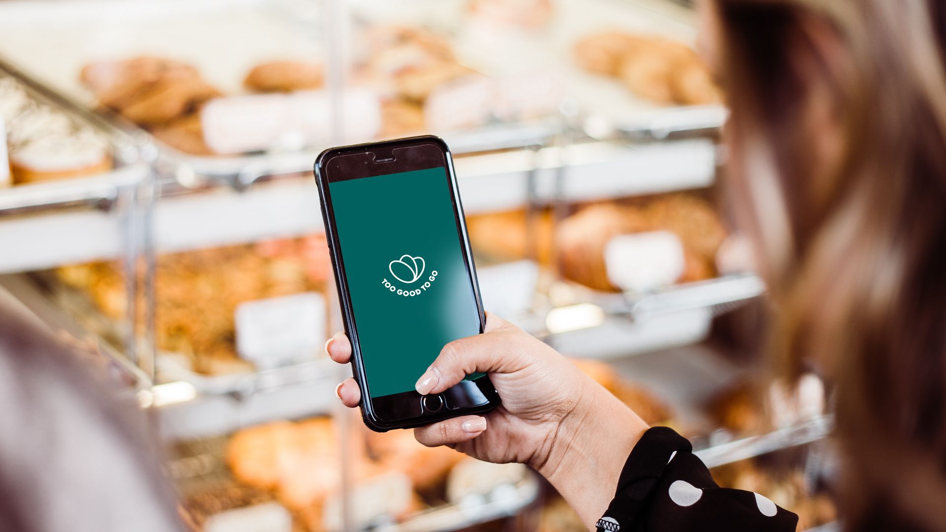 A phone that says, "Too Good to Go" in a bakery.