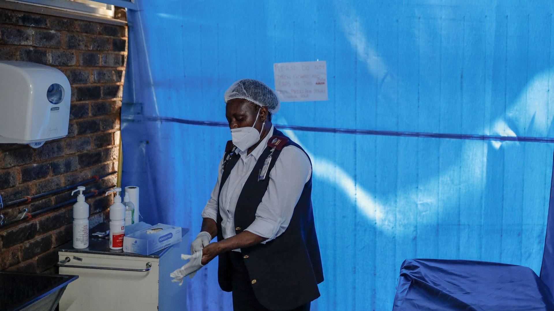 A doctor puts on gloves in a hospital.