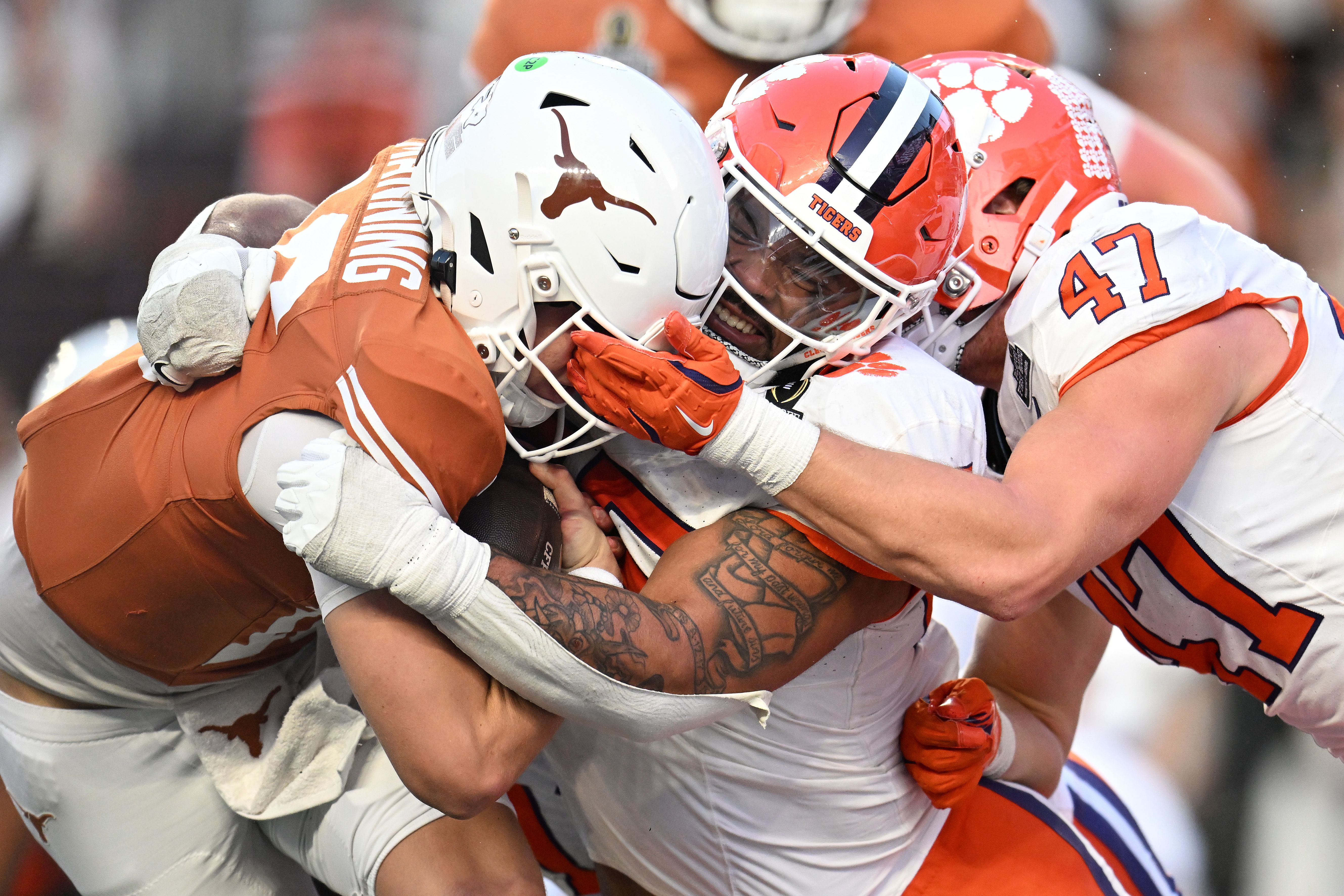 Arch Manning #16 of the Texas Longhorns is tackled by Payton Page #55 and Sammy Brown #47 of the Clemson Tigerss during the third quarter in the Playoff First Round Game at Darrell K Royal-Texas Memorial Stadium on December 21, 2024 in Austin, Texas. (Photo by Jack Gorman/Getty Images)