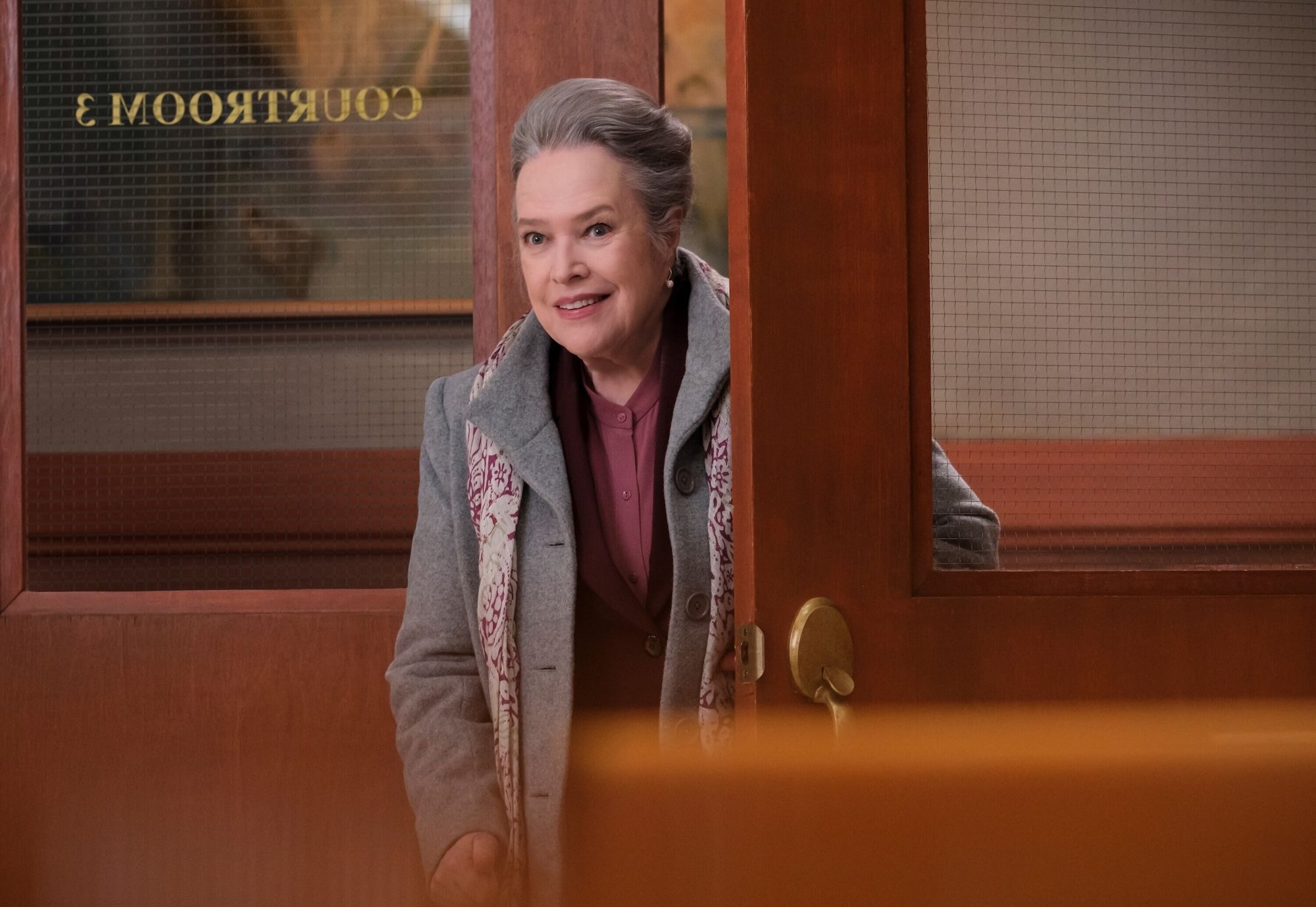 Kathy Bates walking into a courtroom.