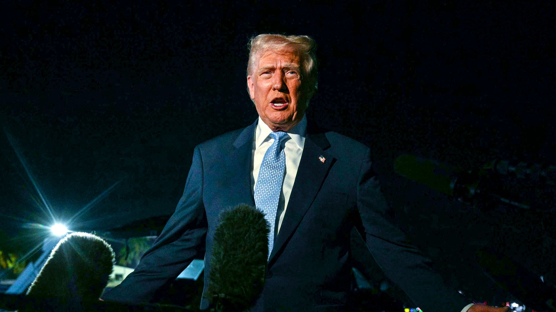 Trump standing in front of microphones