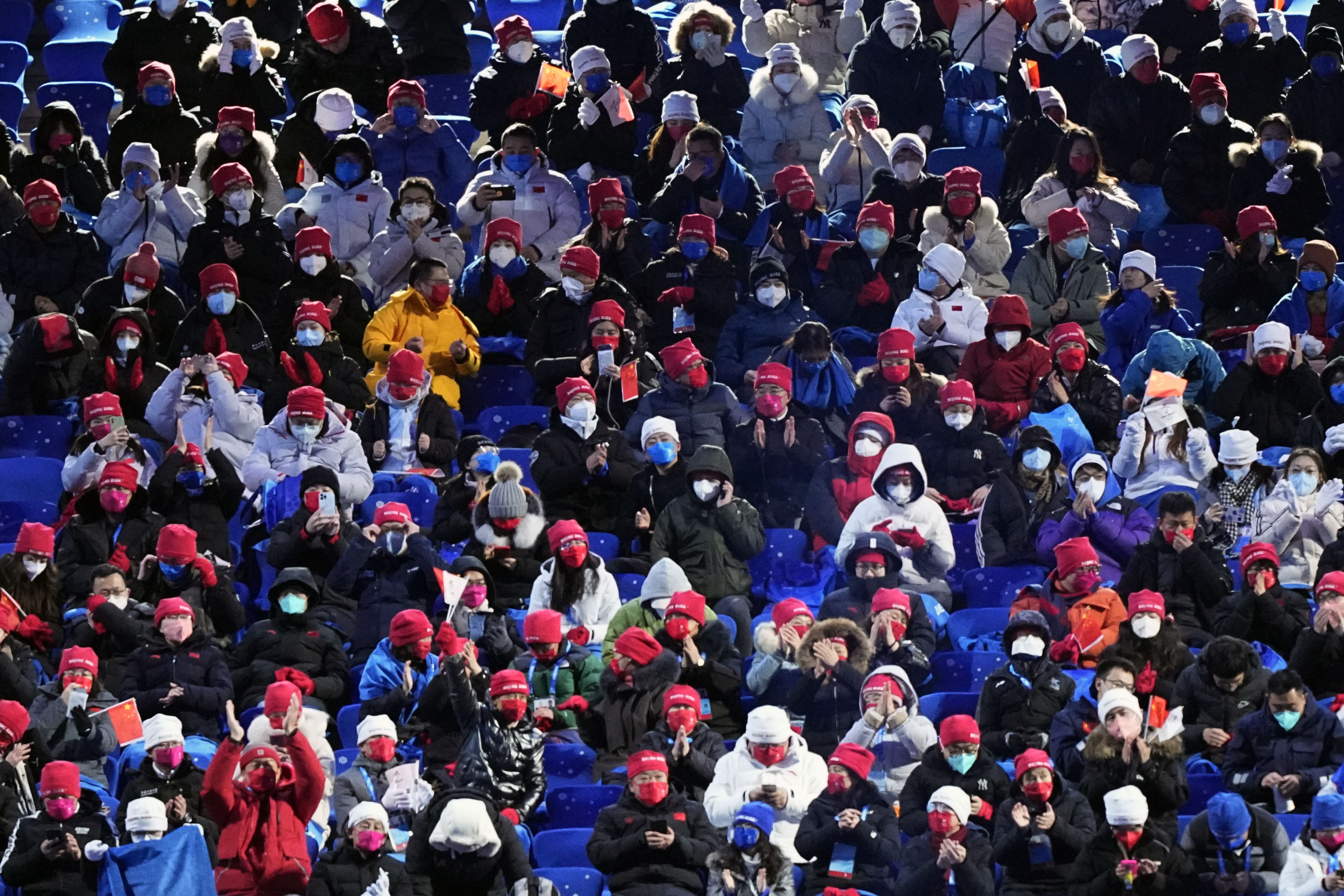 Spectators wait for the start of the opening ceremony of the 2022 Winter Olympics.