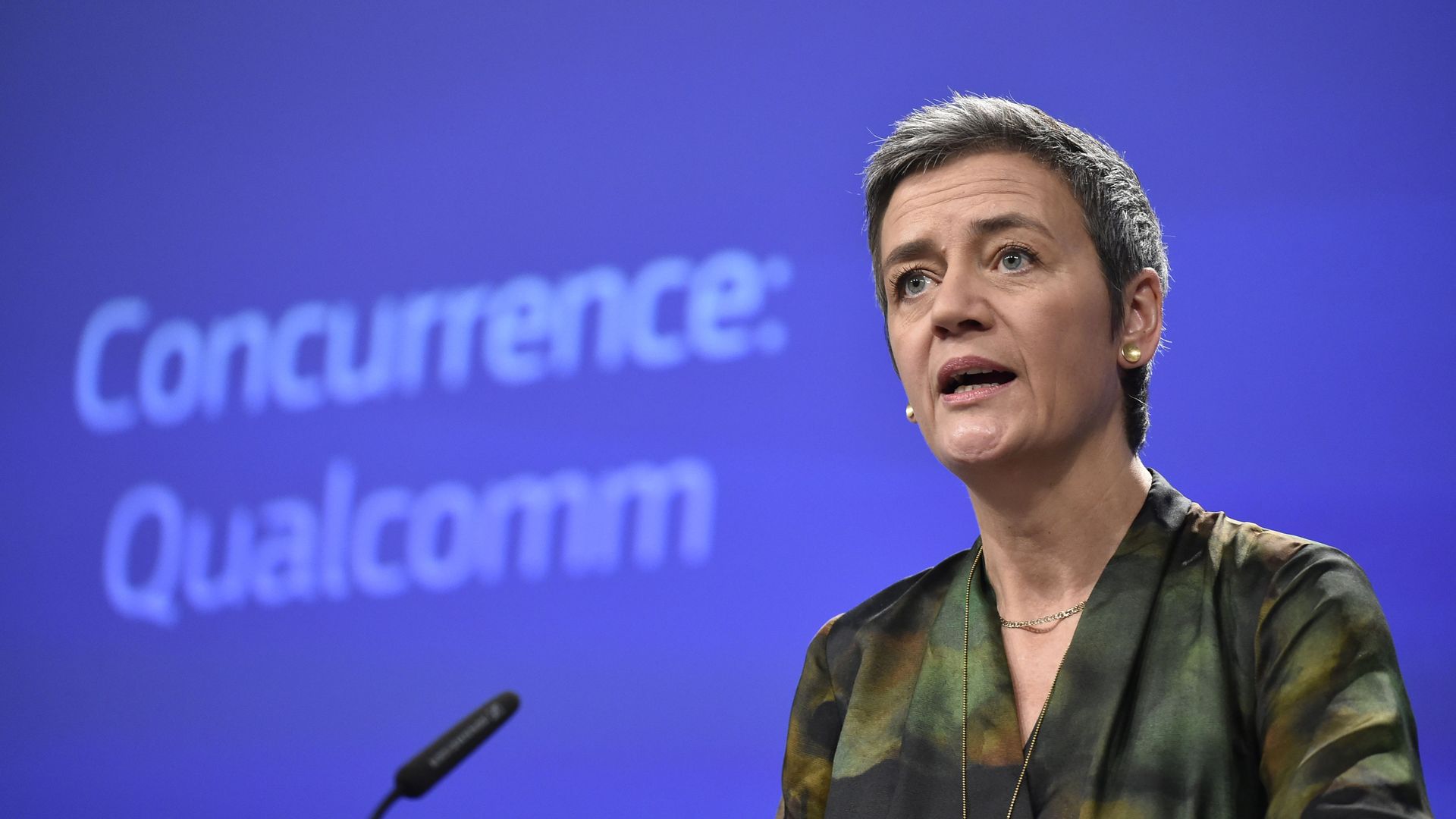 Margrethe Vestager speaks in front of a blue backdrop