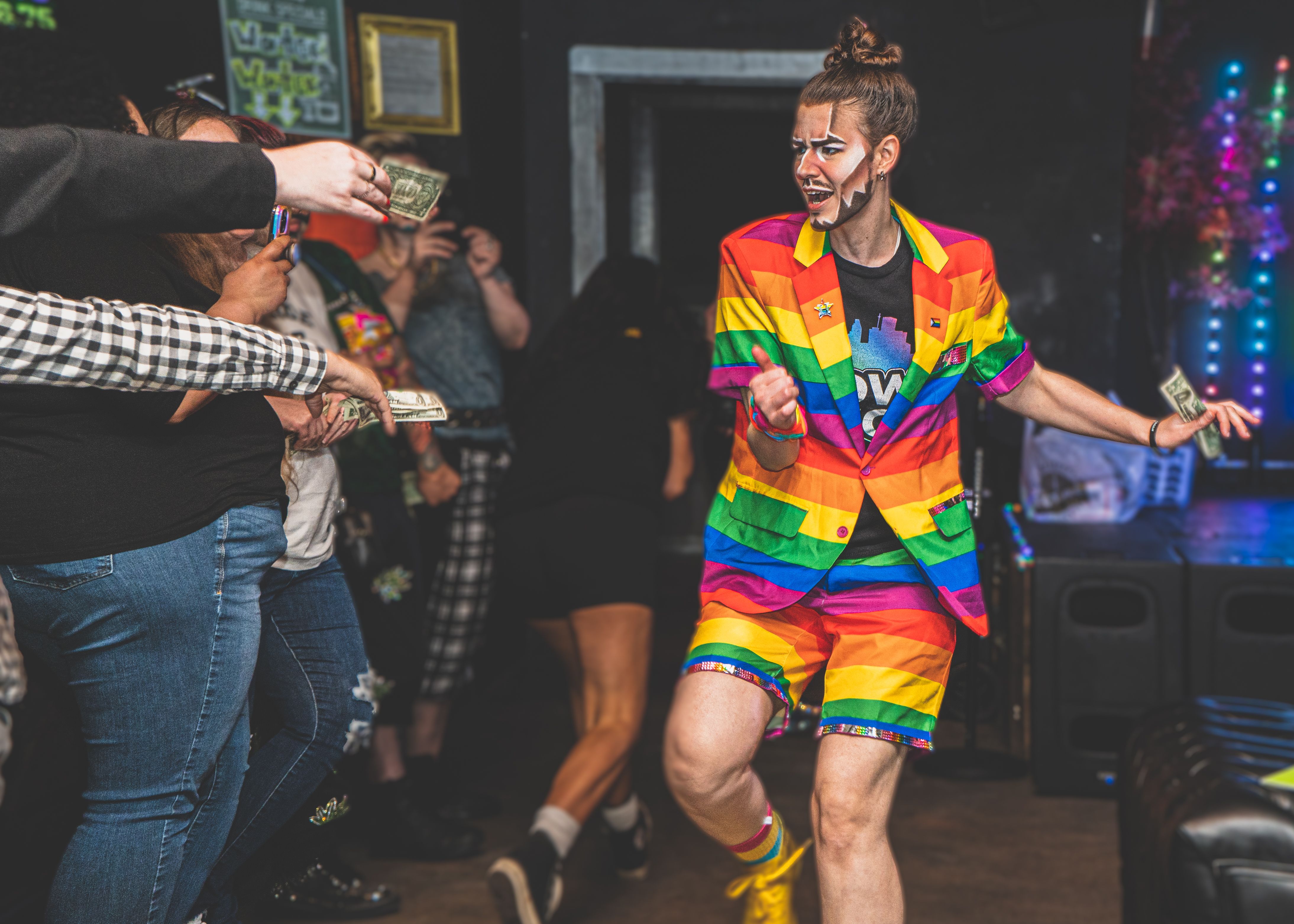 Photo of a drag king wearing a rainbow outfit. 