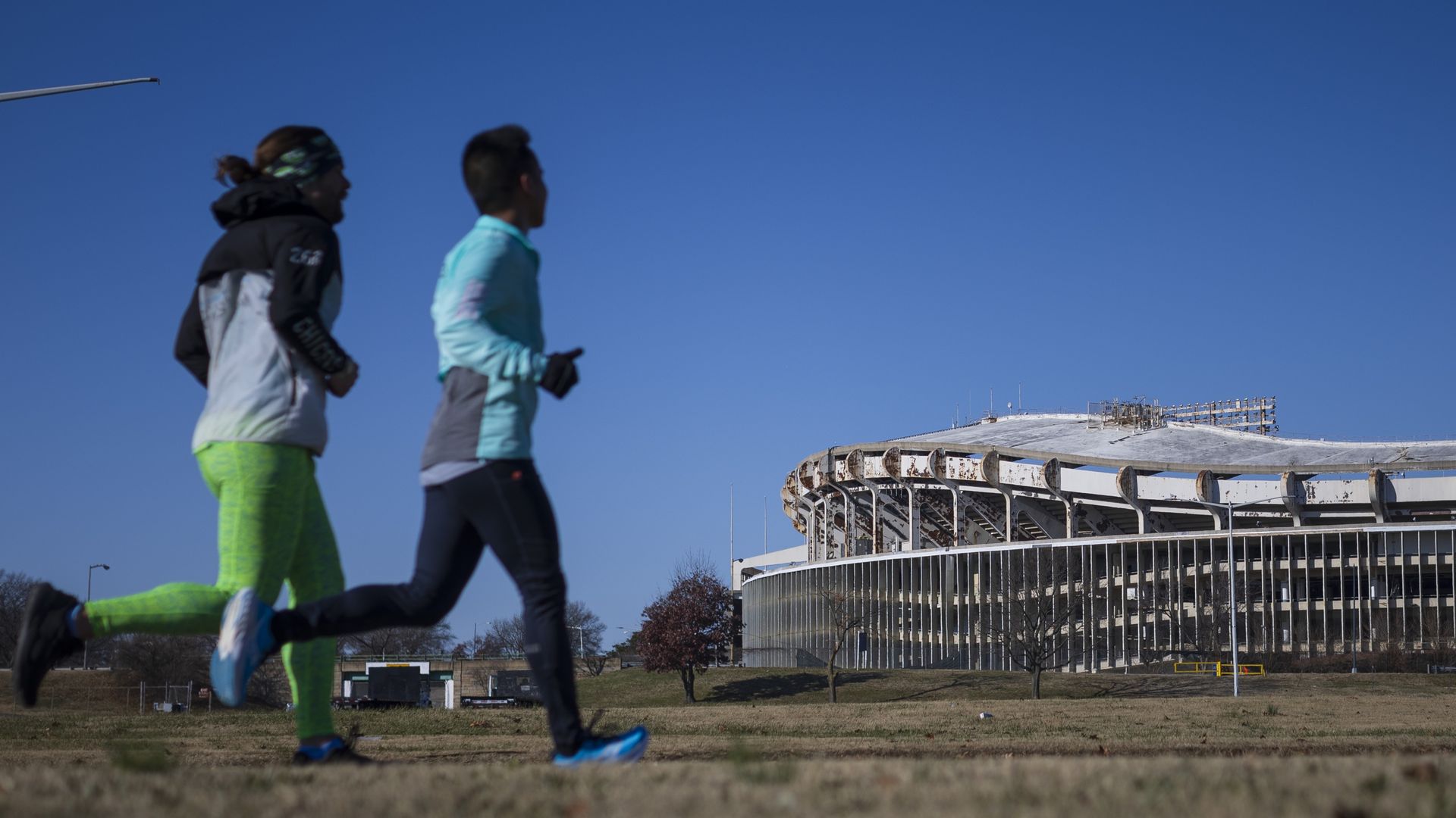 People run in the foreground of the RFK Stadium site