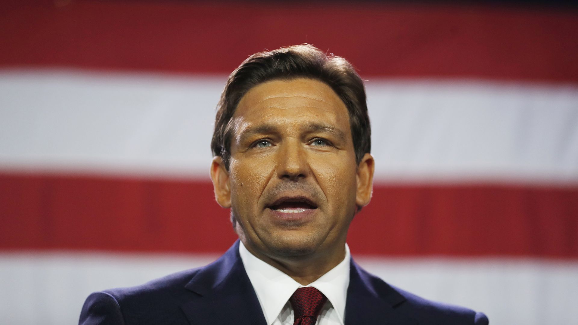 Florida Gov. Ron DeSantis in front of an American flag.