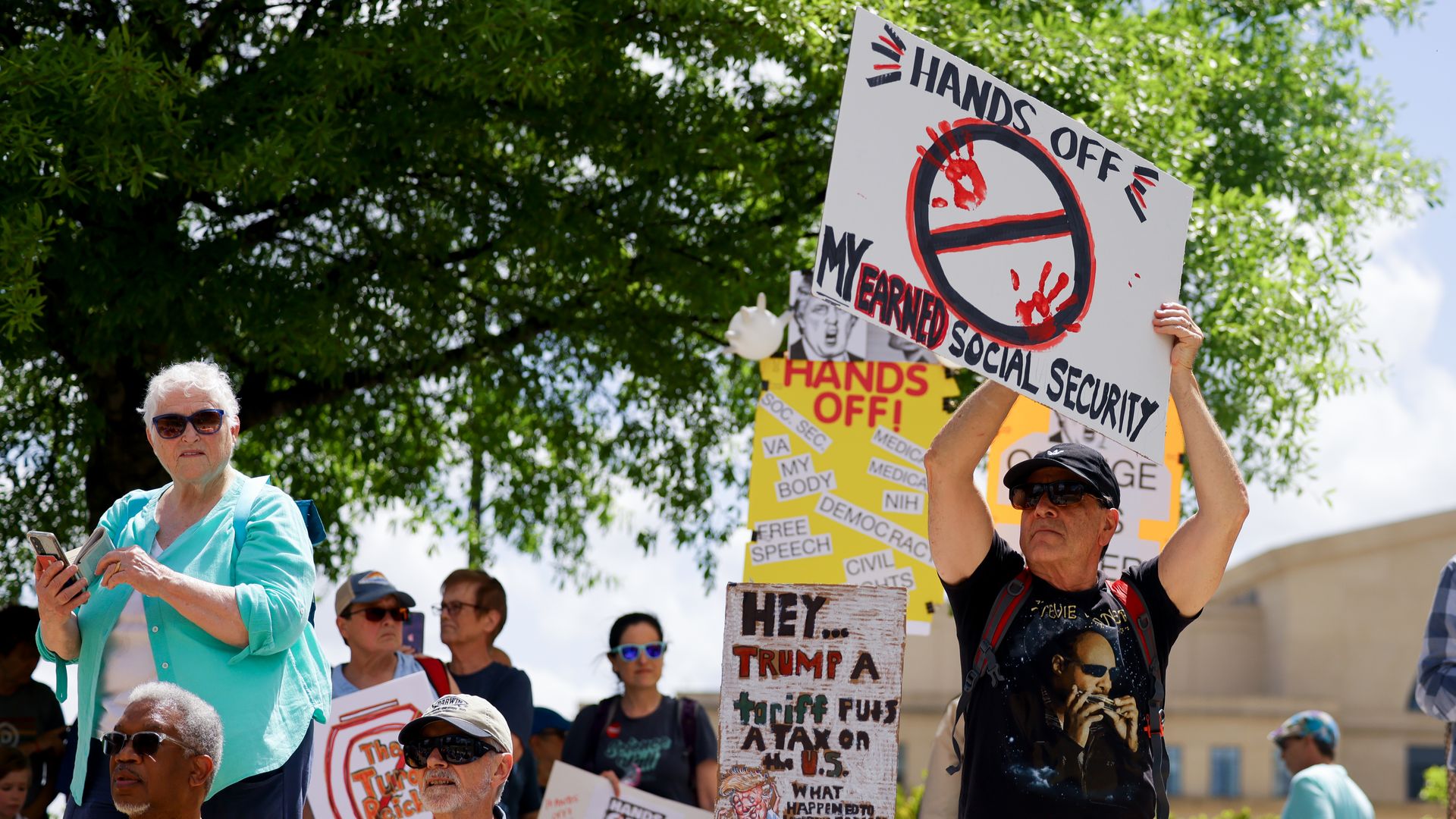 Demonstrators attend nationwide "Hands Off!" protest against US President Donald Trump and his advisor, Tesla CEO Elon Musk at Liberty Plaza on April 05, 2025 in Atlanta, Georgia. 