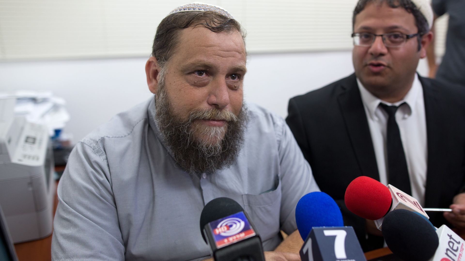 Israeli leader of the extreme right-wing movement Lehava, Benzi Gopstein (L) listens to journalists' questions next to his then-lawyer Itamar Ben Gvir on August 11, 2015