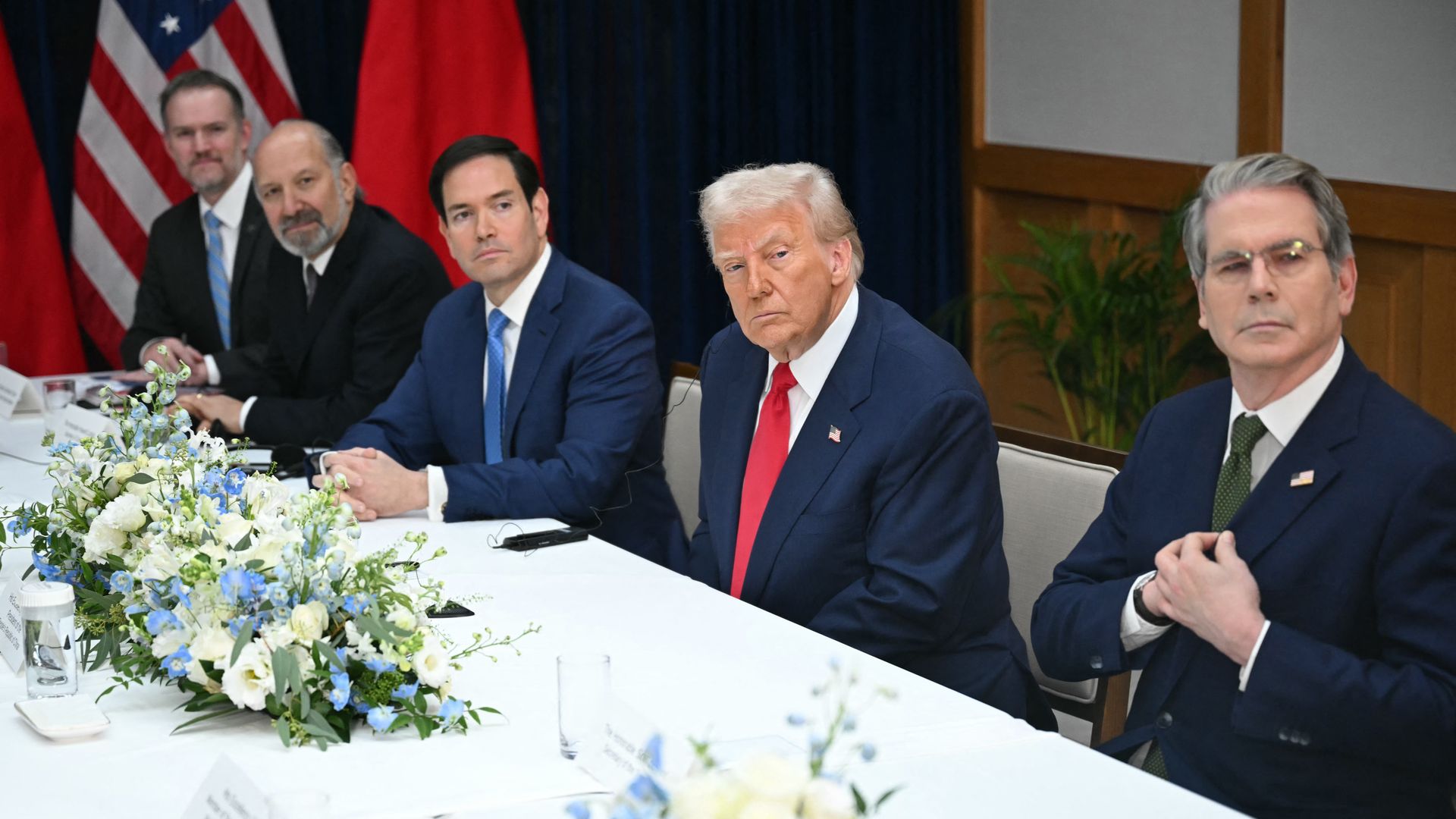 President Trump, seated, in a suit and red tie, flanked by members of his Cabinet. 