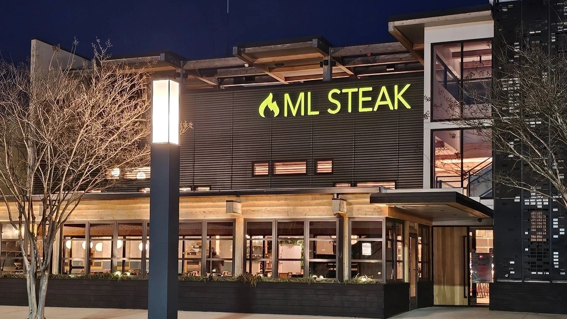 The outside of a steakhouse restaurant called ML steak - with very clean lines. 