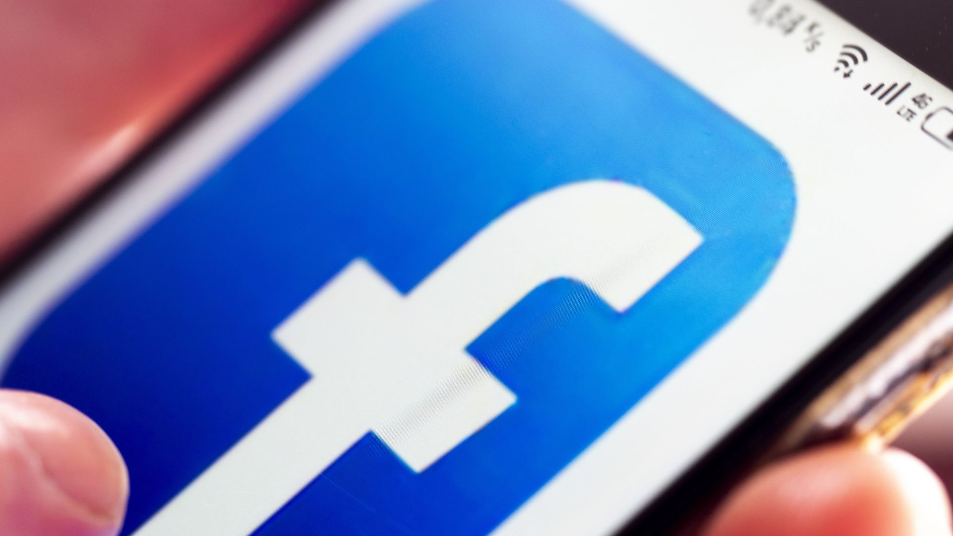 A photo of the Facebook logo displayed on a smartphone screen.