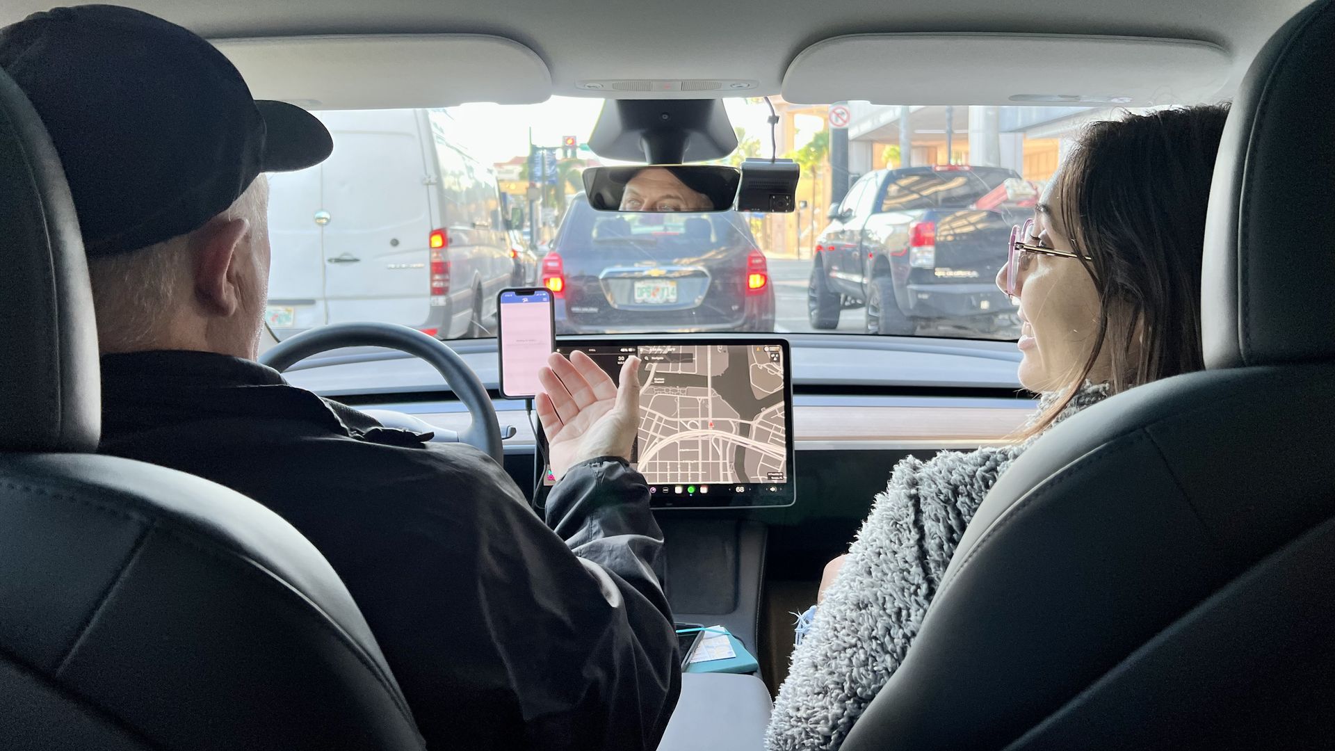 Selene sits in the front passenger seat and looks at her DASH driver while he talks