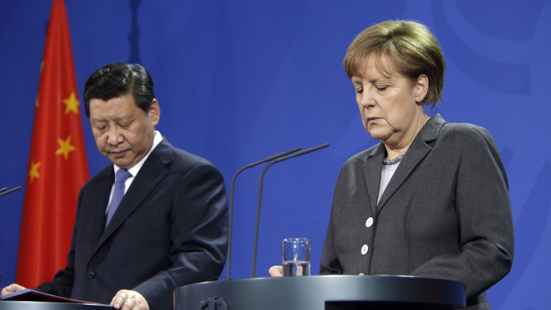 Xi and Merkel both look down
