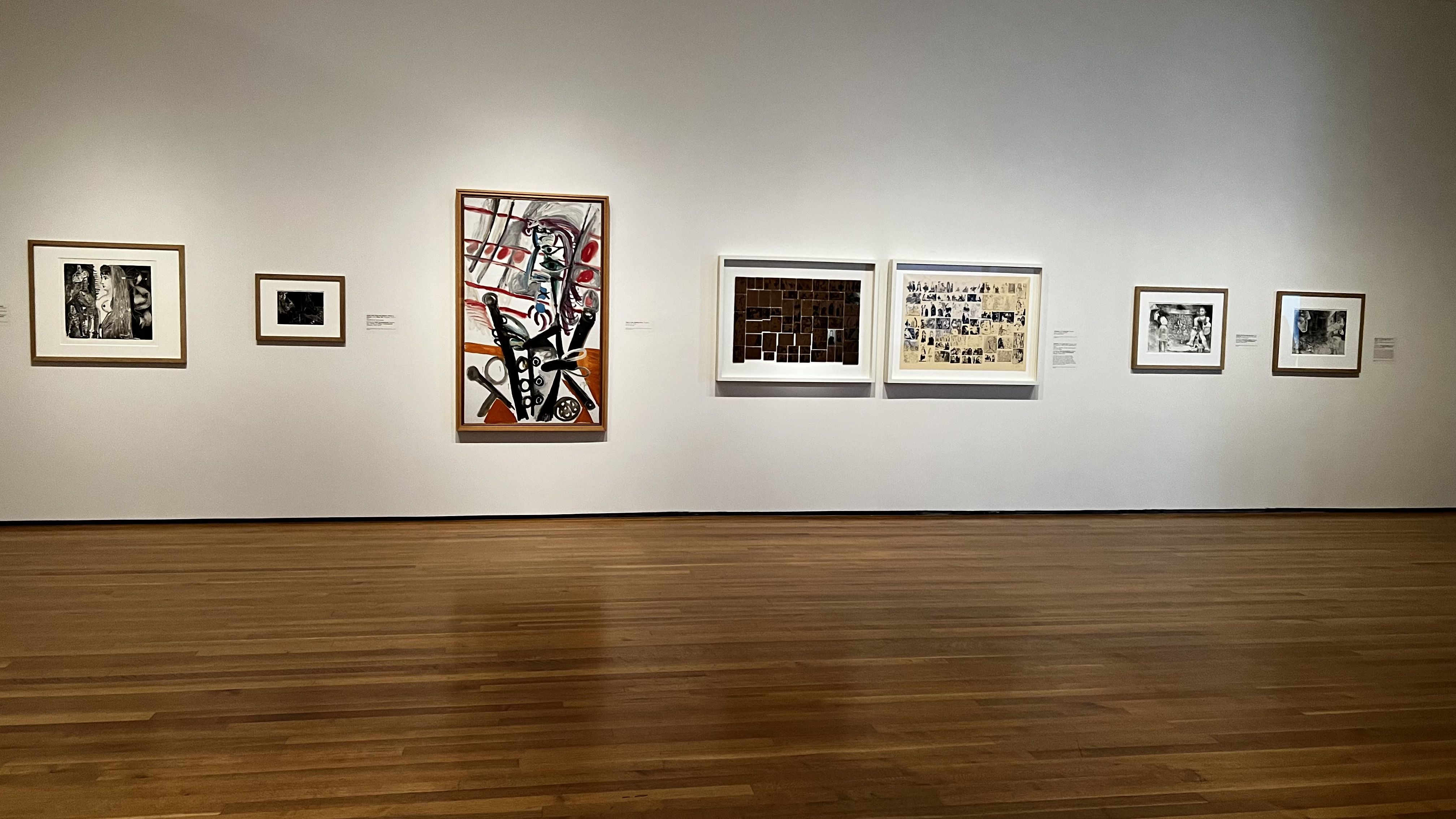 Artwork hangs on a white wall. 