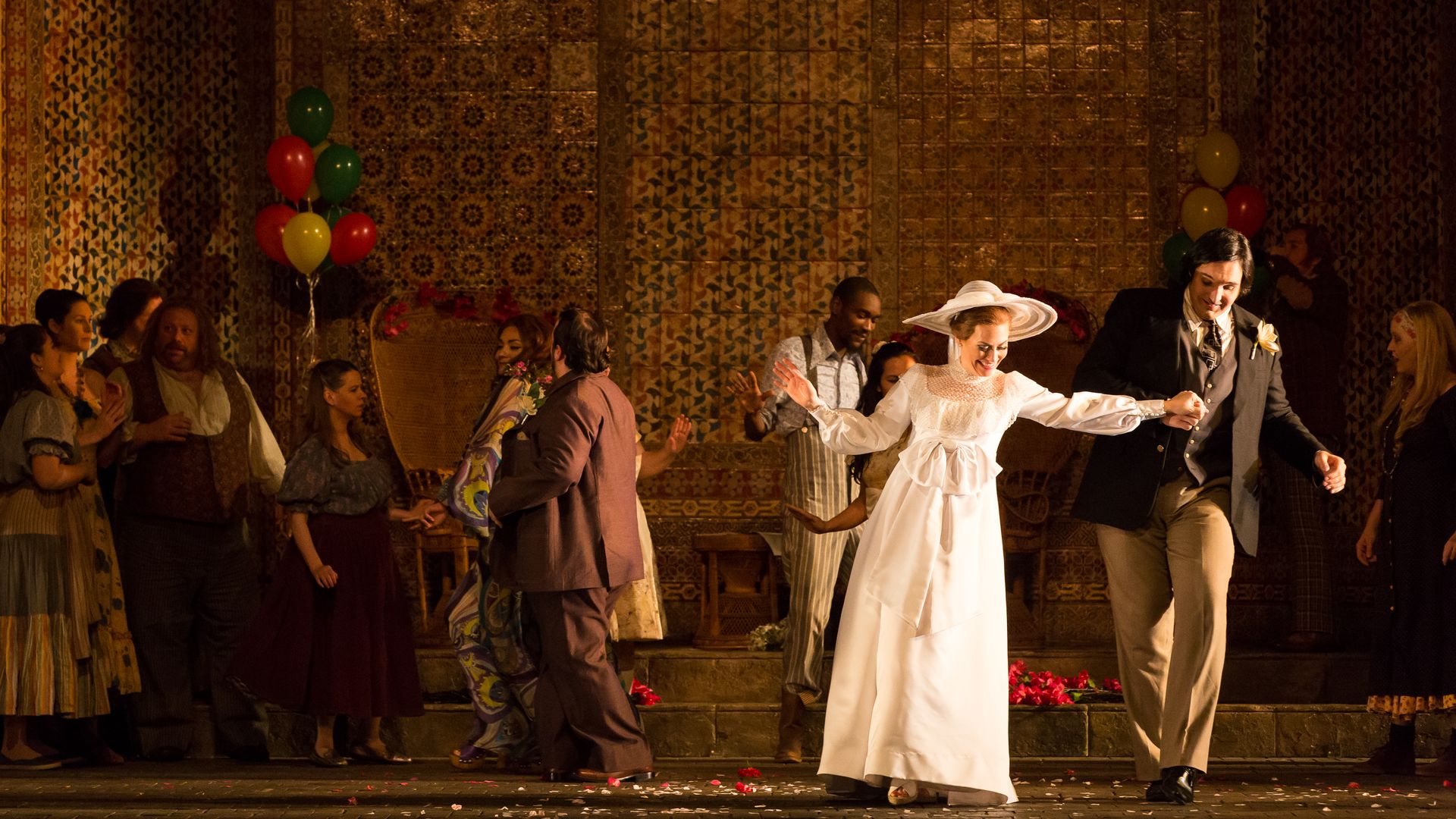 Photo of a woman in a wedding dress with a man on a theater stage.