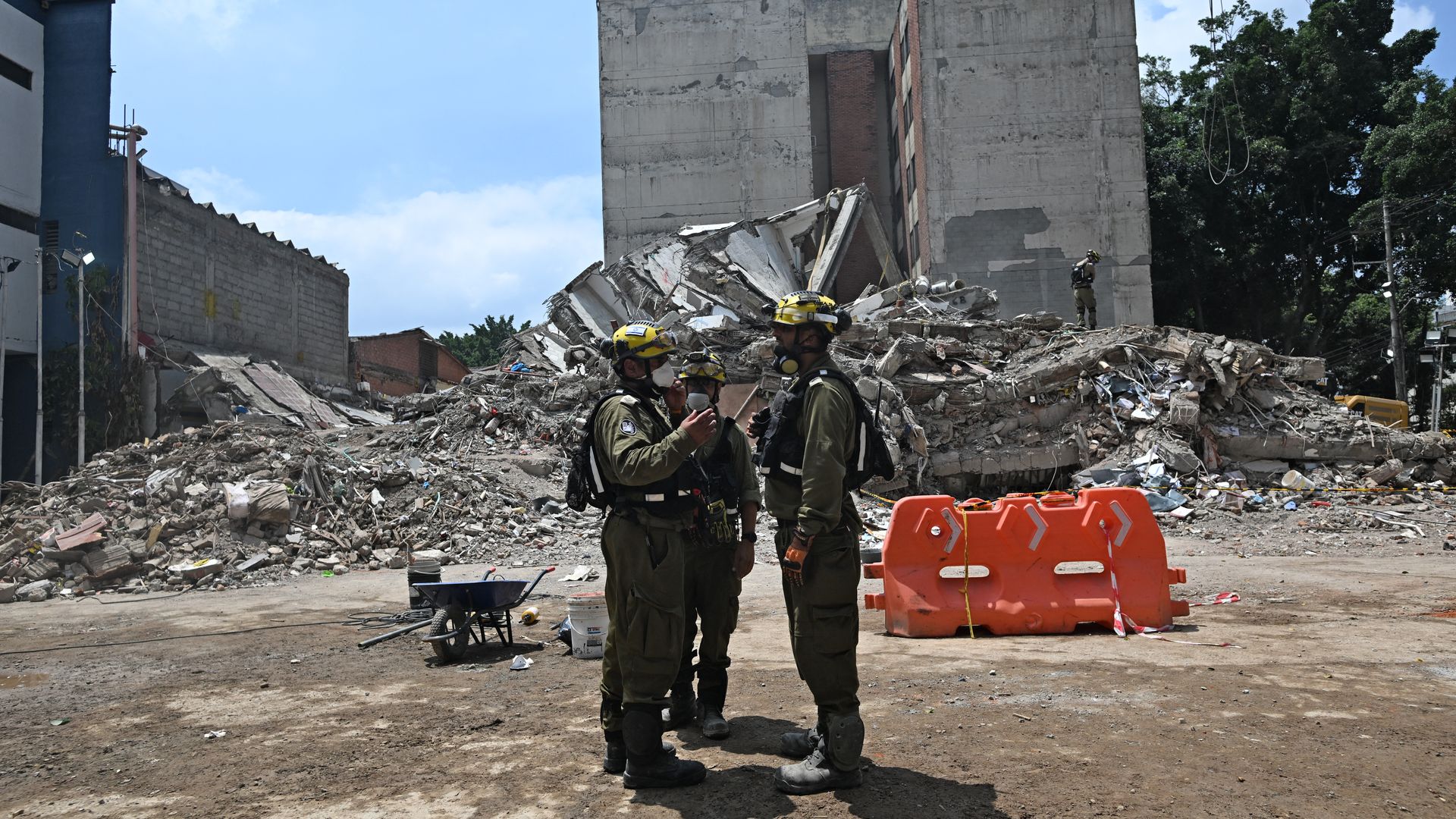 Three Israeli rescue workers are seen next to the rubble of the fallen Vanessa building in Cali, Colombia, on August 18, 2026, eight days after a 7.4 earthquake hit the region.
