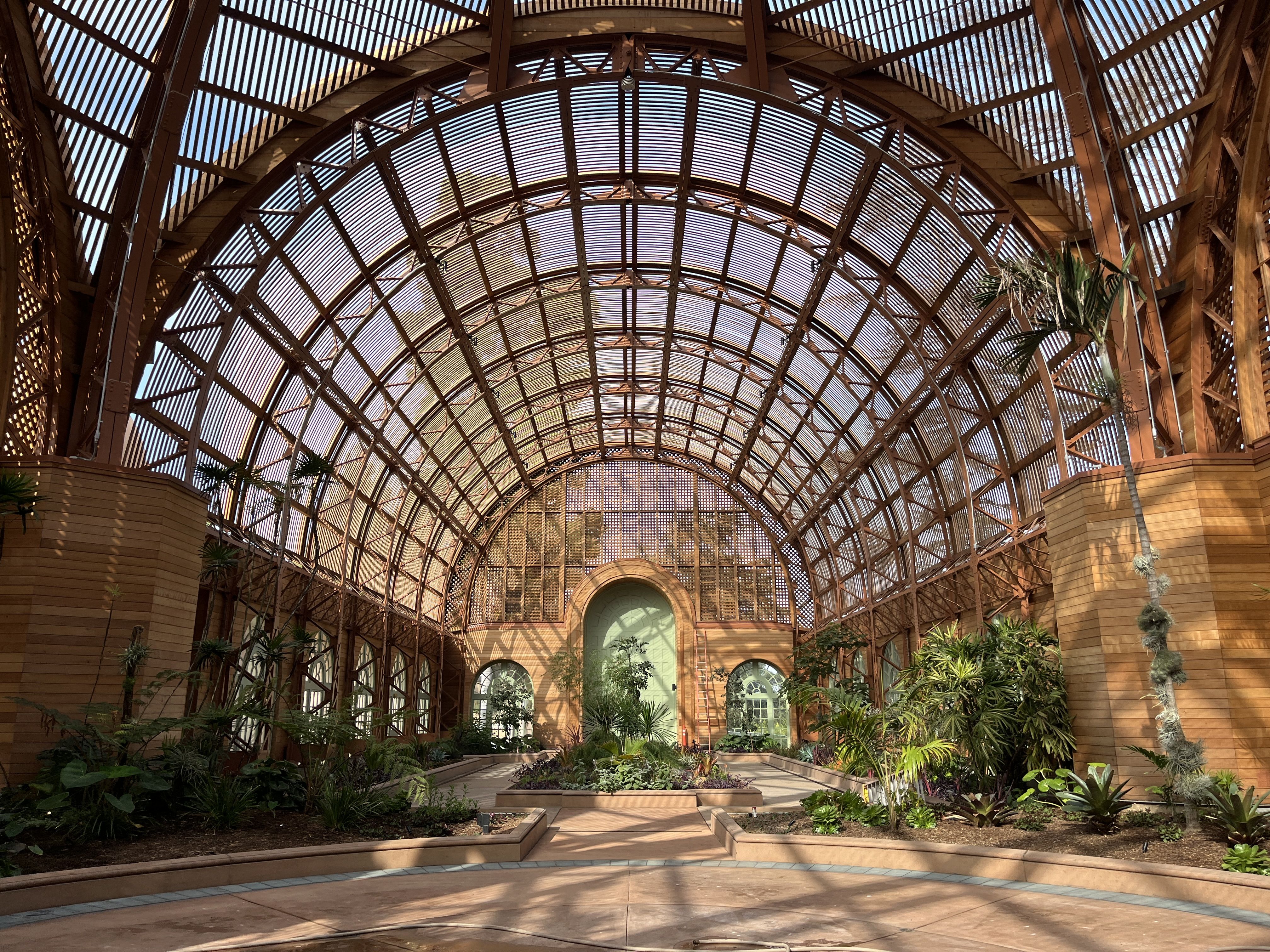 The interior of the Botanical Building features a domed wood lath structure and greenery. 
