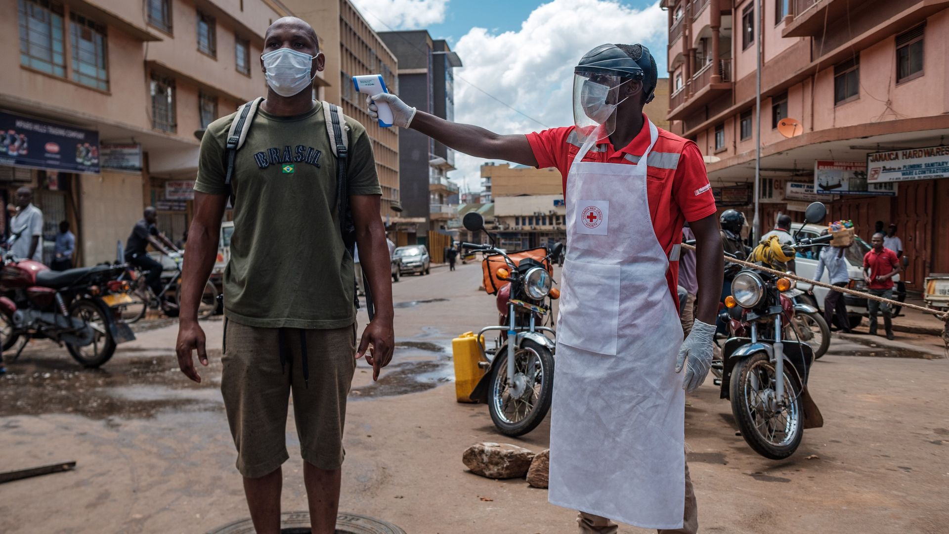 A man gets a covid screening with a thermometer.