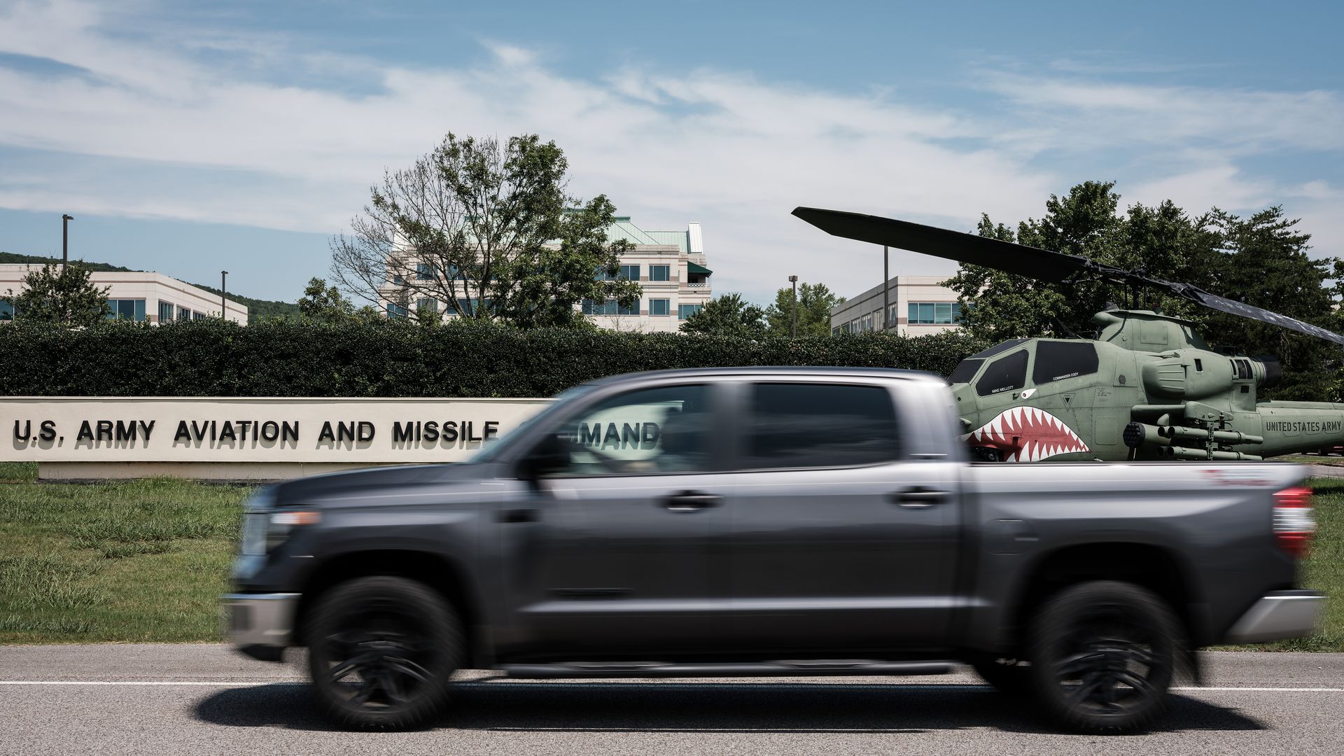 A truck passes by a helicopter and a sign reading "U.S. Army Aviation and Missile Command" on Redstone Arsenal in Huntsville, Alabama. 