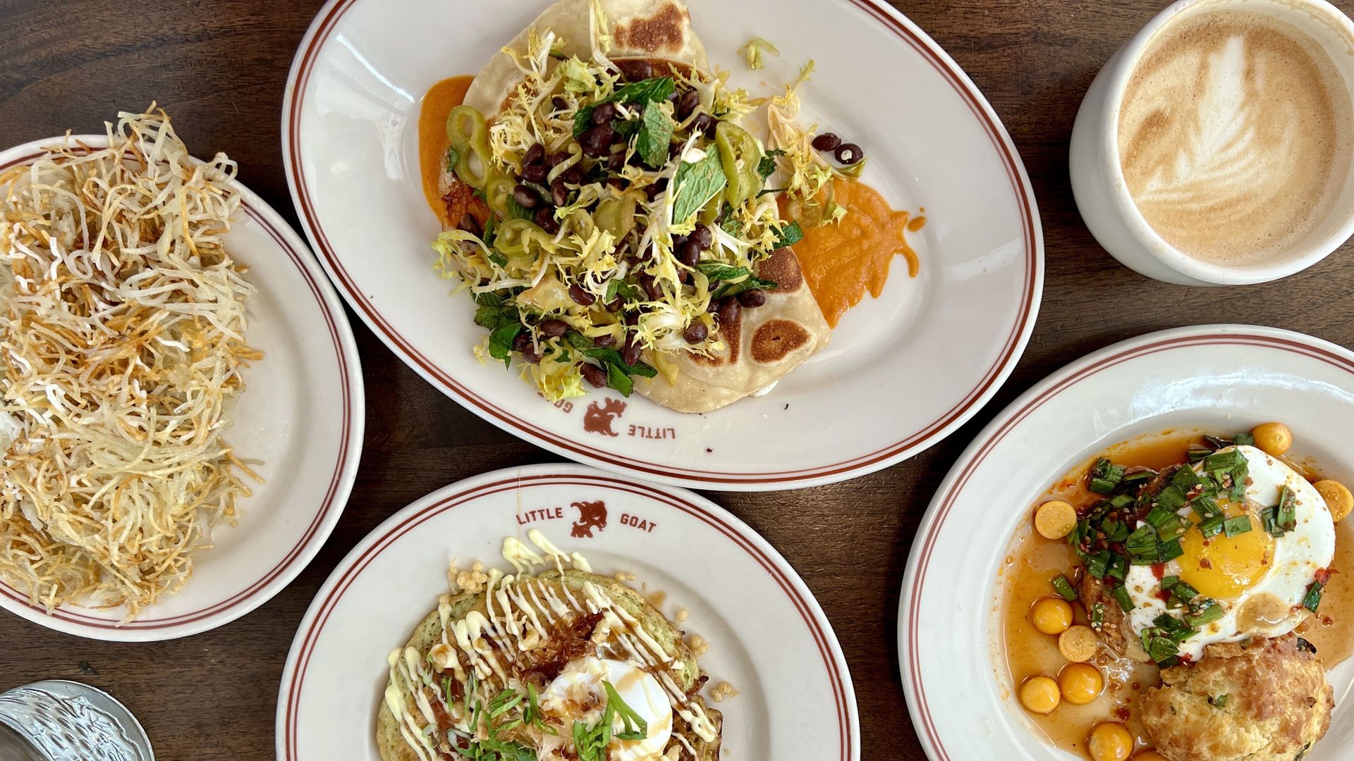 A recent Axios Chicago team breakfast of Little Goat's (clockwise) paratha burrito, lattes, This Little Goat Went to China and okonomiyaki and hash browns.