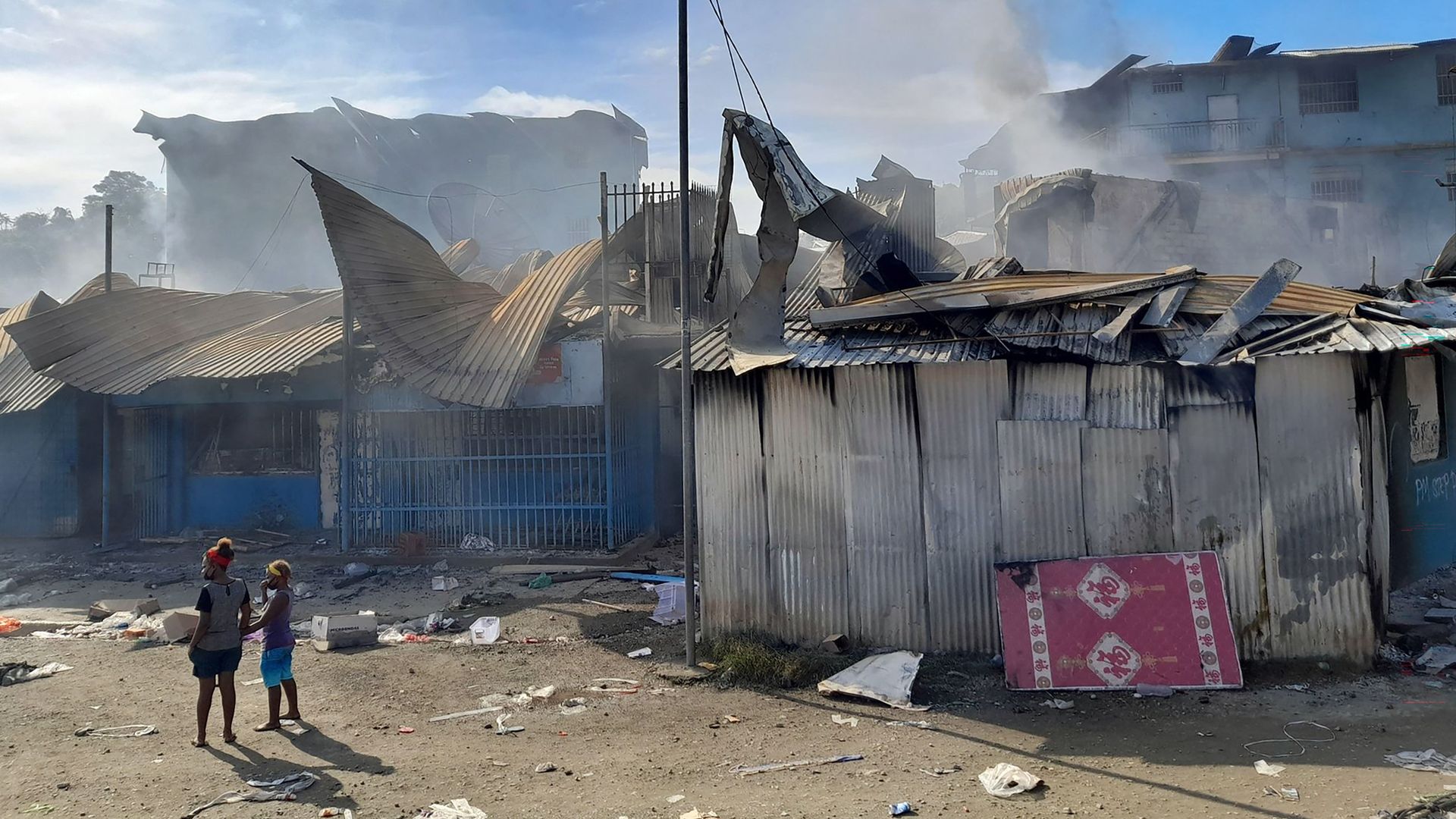 Smoke rises from a burnt out buildings in Honiara's Chinatown on November 26, 2021 after two days of rioting.