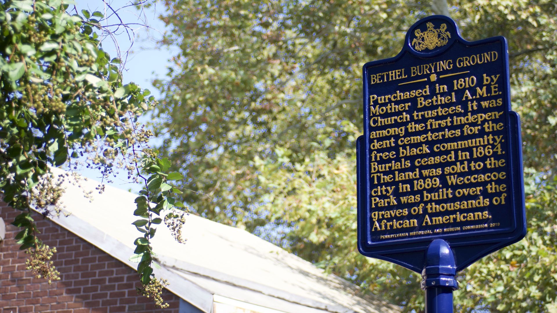 A blue historical marker stands outside the Bethel Burying Grounds in Philadelphia's Queen Village neighborhood.