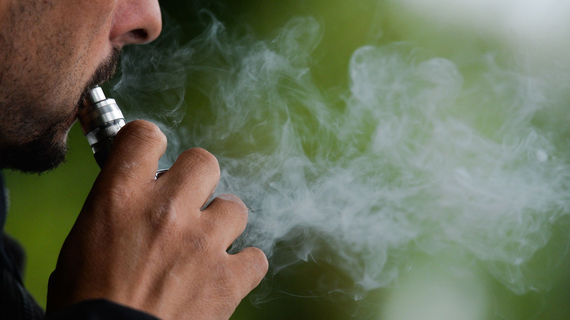 A man smokes an e-cigarette.