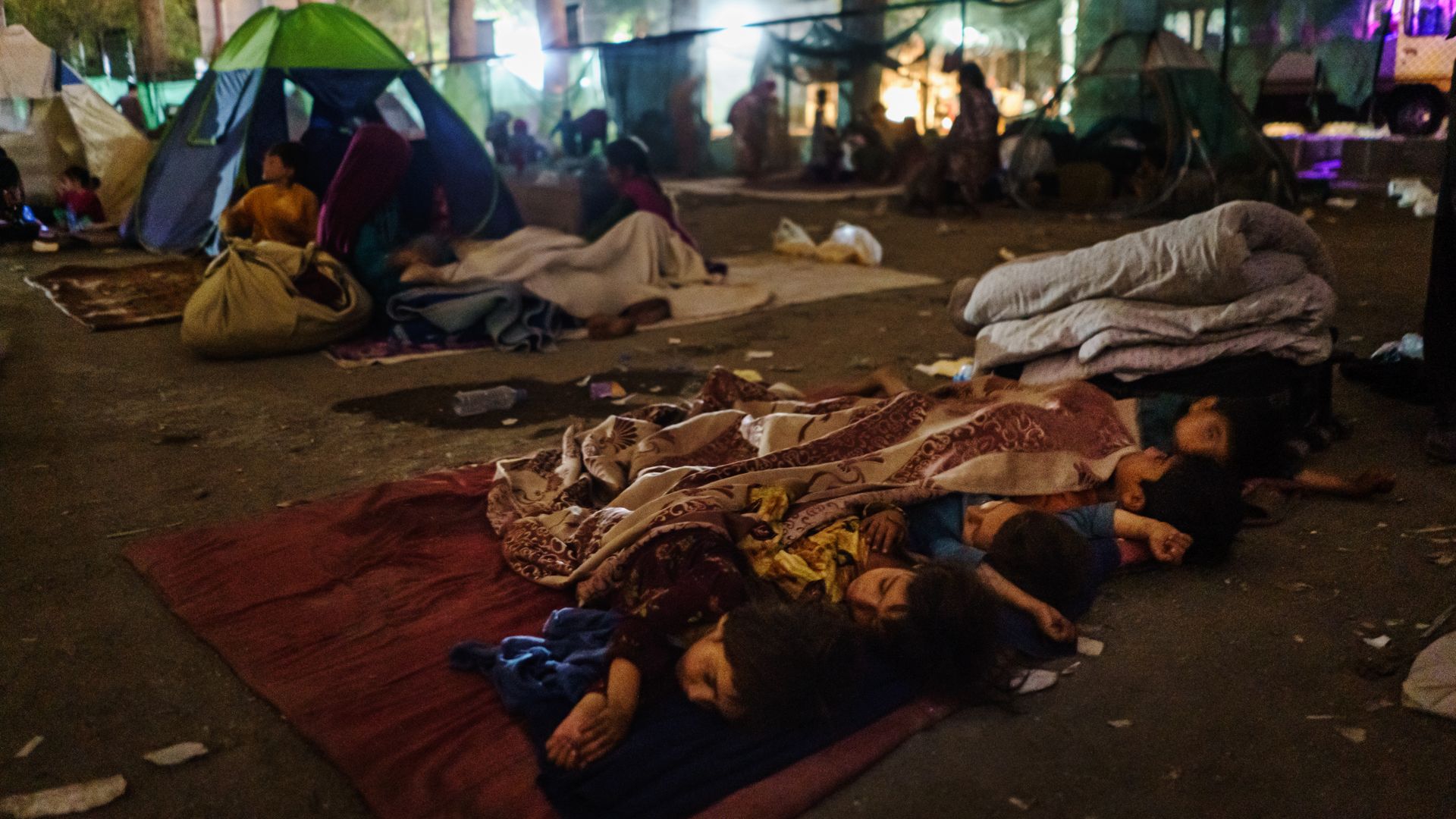 Children sleeping on a mat in the street