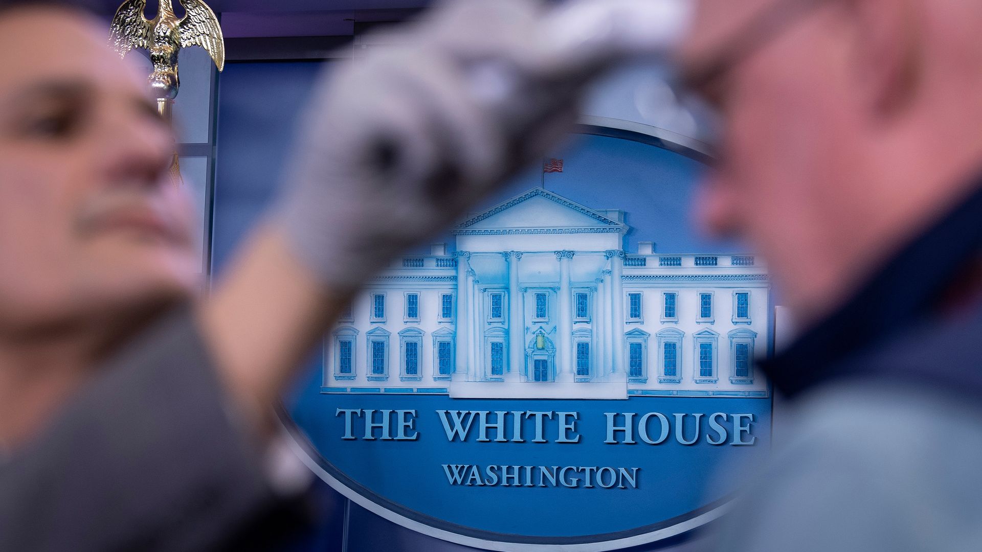 Members of the press have their temperatures taken before a COVID-19 briefing at the White House.