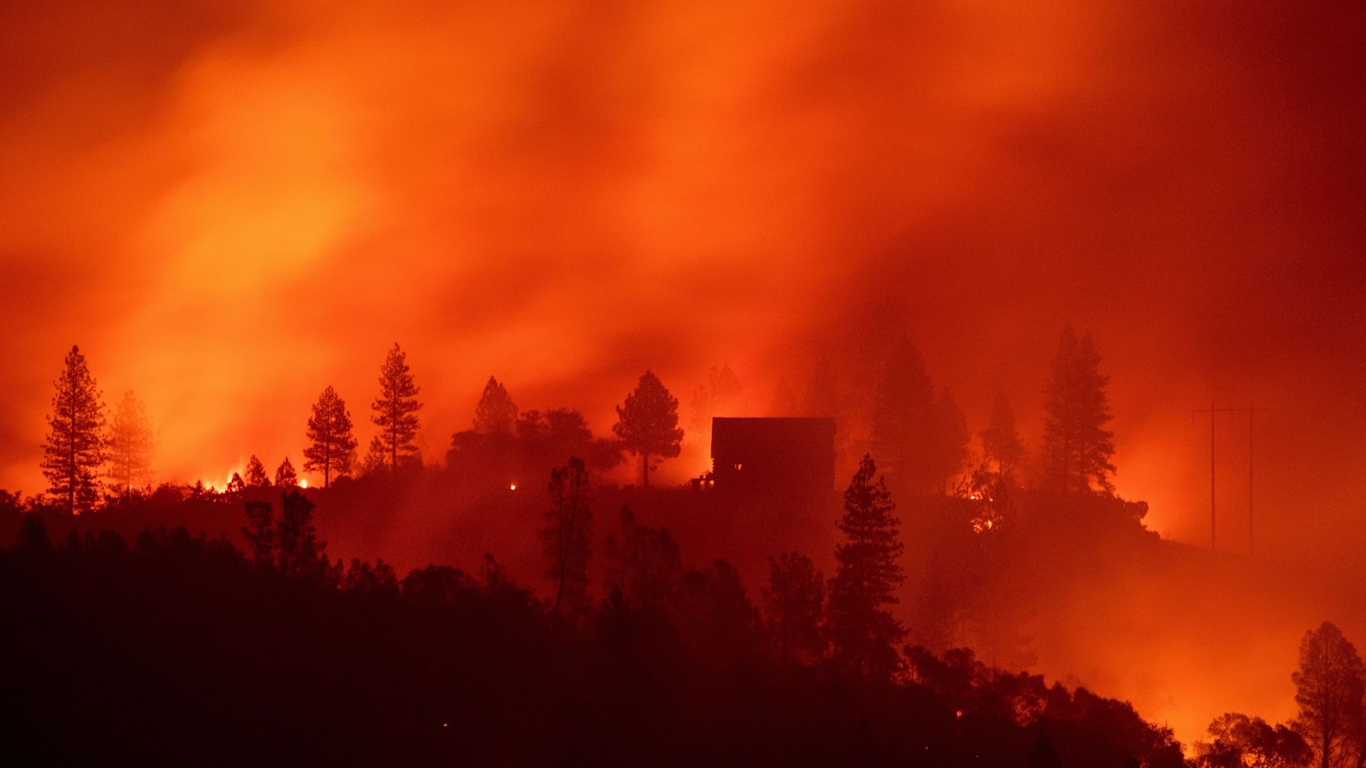 Flames from the Camp fire burn near a home atop a ridge near Big Bend, California, on November 10, 2018. 
