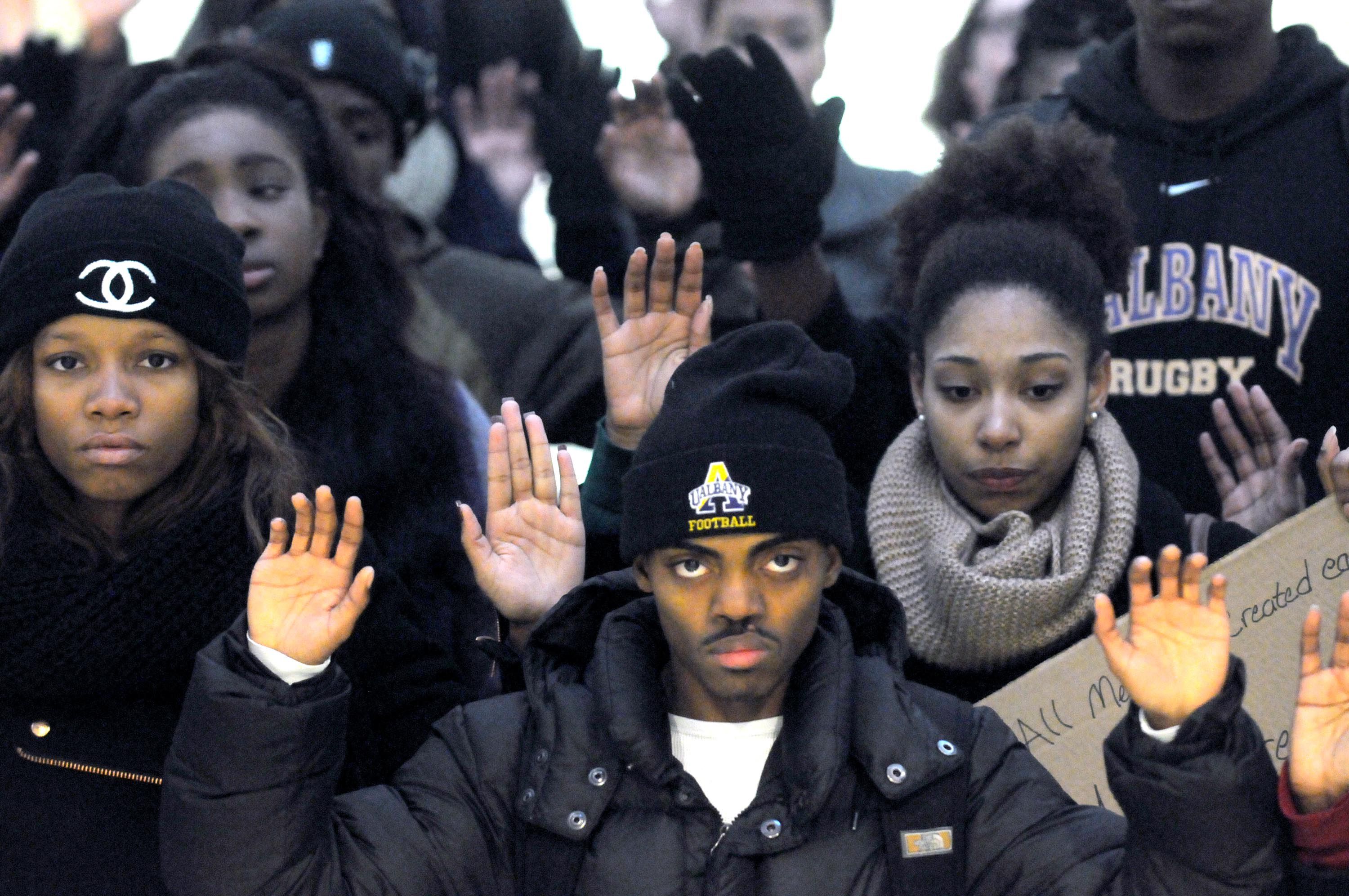 Joshua Johnson, center, is joined by other University at Albany students to demonstrate against the grand jury decision in Ferguson, Mo. Wednesday Dec. 3, 2014, at University Hall in Albany, N.Y. The protest was organized by Iota Phi Theta fraternity and Zeta Phi Beta sorority.