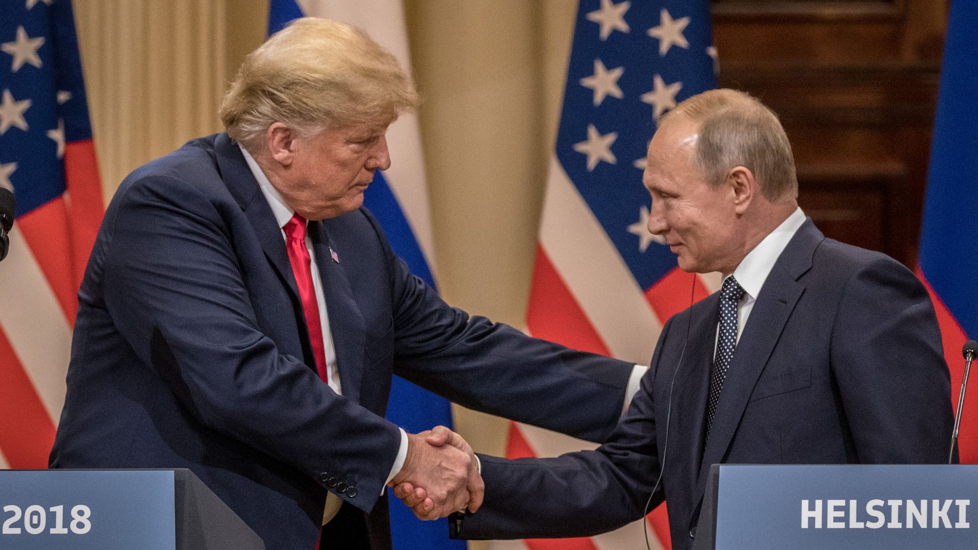 Trump and Putin smile and shake hands behind podiums in Helsinki