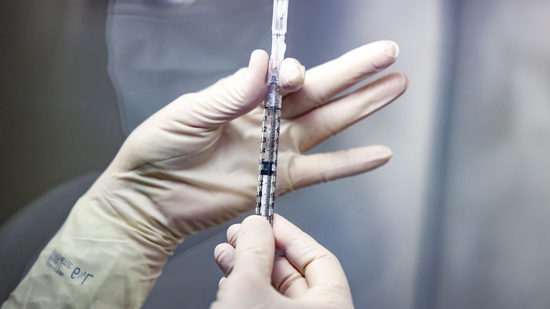 Picture of a hand with surgical gloves holding a coronavirus vaccine