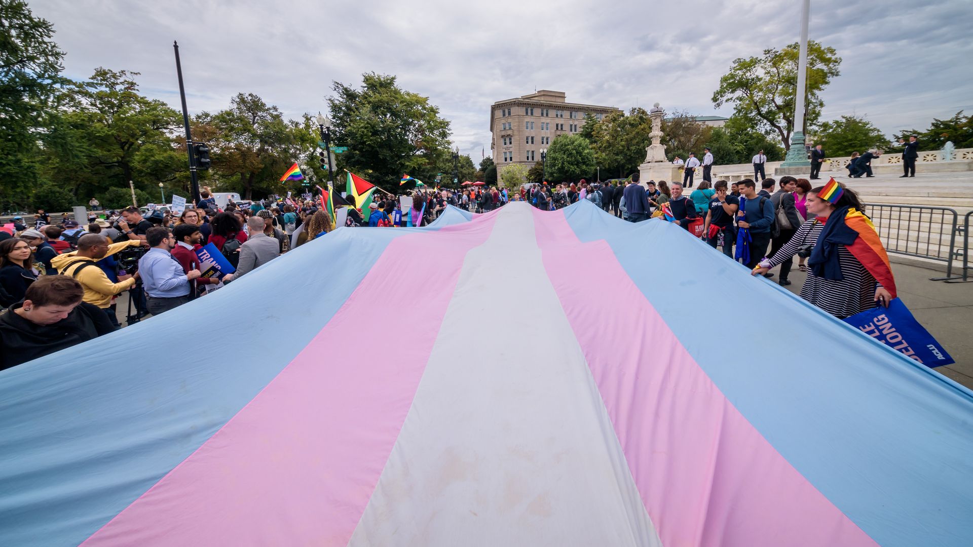 Photo of a giant Trans Flag unfurled outside the Supreme Court