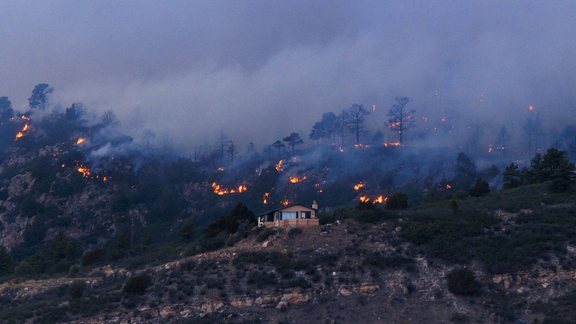 The Aspen Acres fire burns behind a home on July 3 in Rye. Photo: Michael Ciaglo/Getty Images