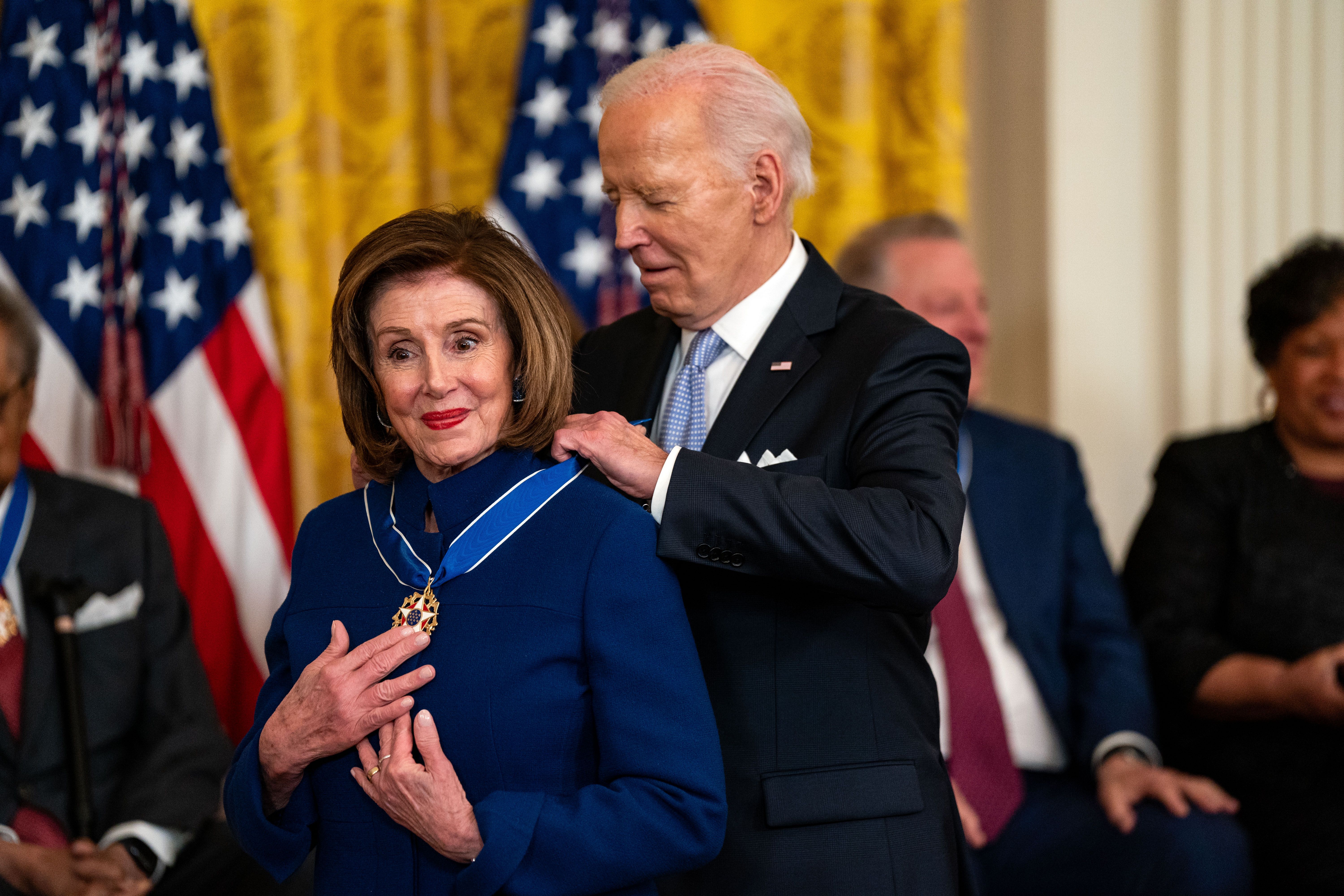 President Biden places the Presidential Medal of Freedom around Nancy Pelosi's neck during a ceremony in the East Room of the White House.