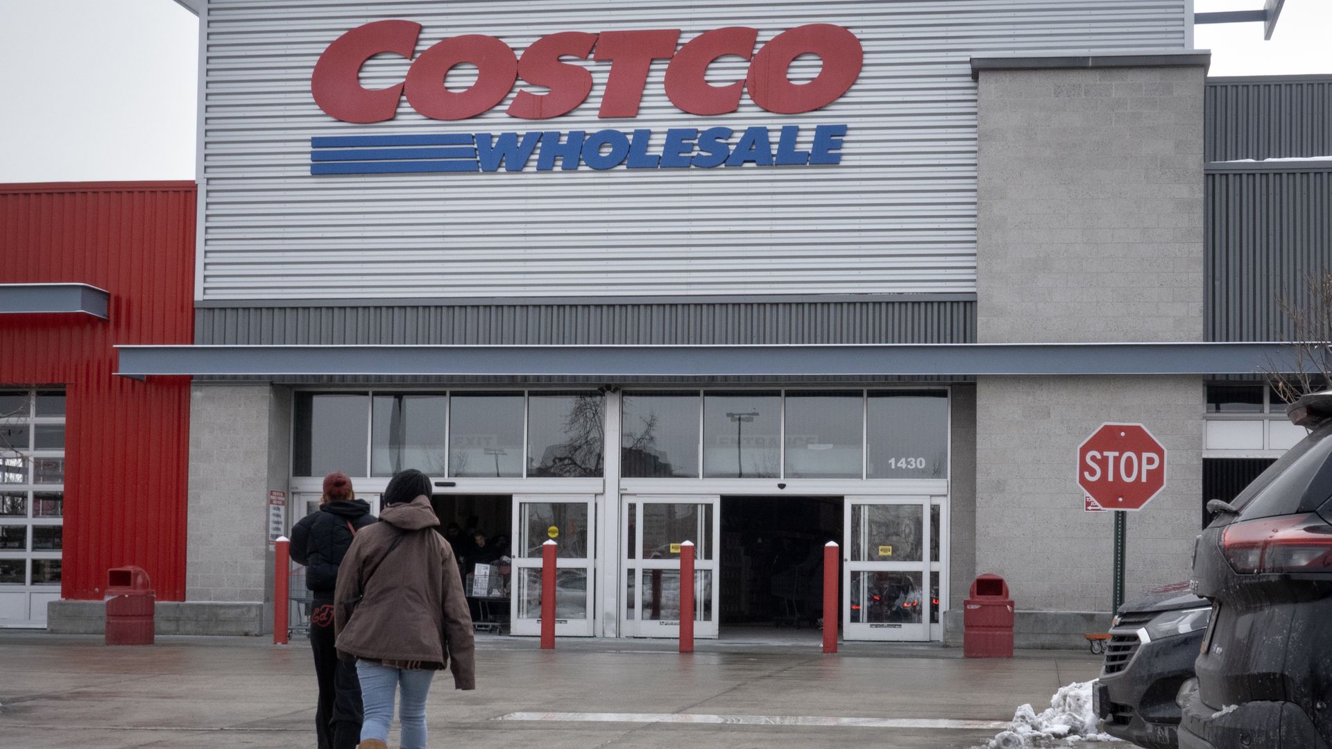 Customers walk in the parking lot outside a Costco store.