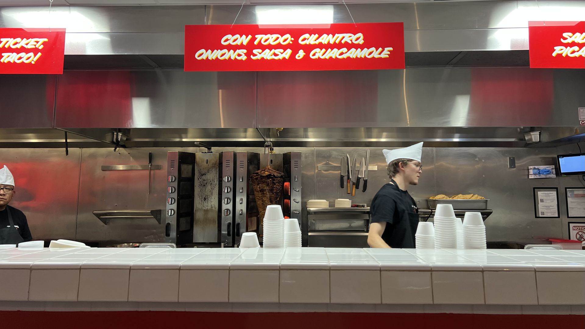 A photo of a person working behind a counter.
