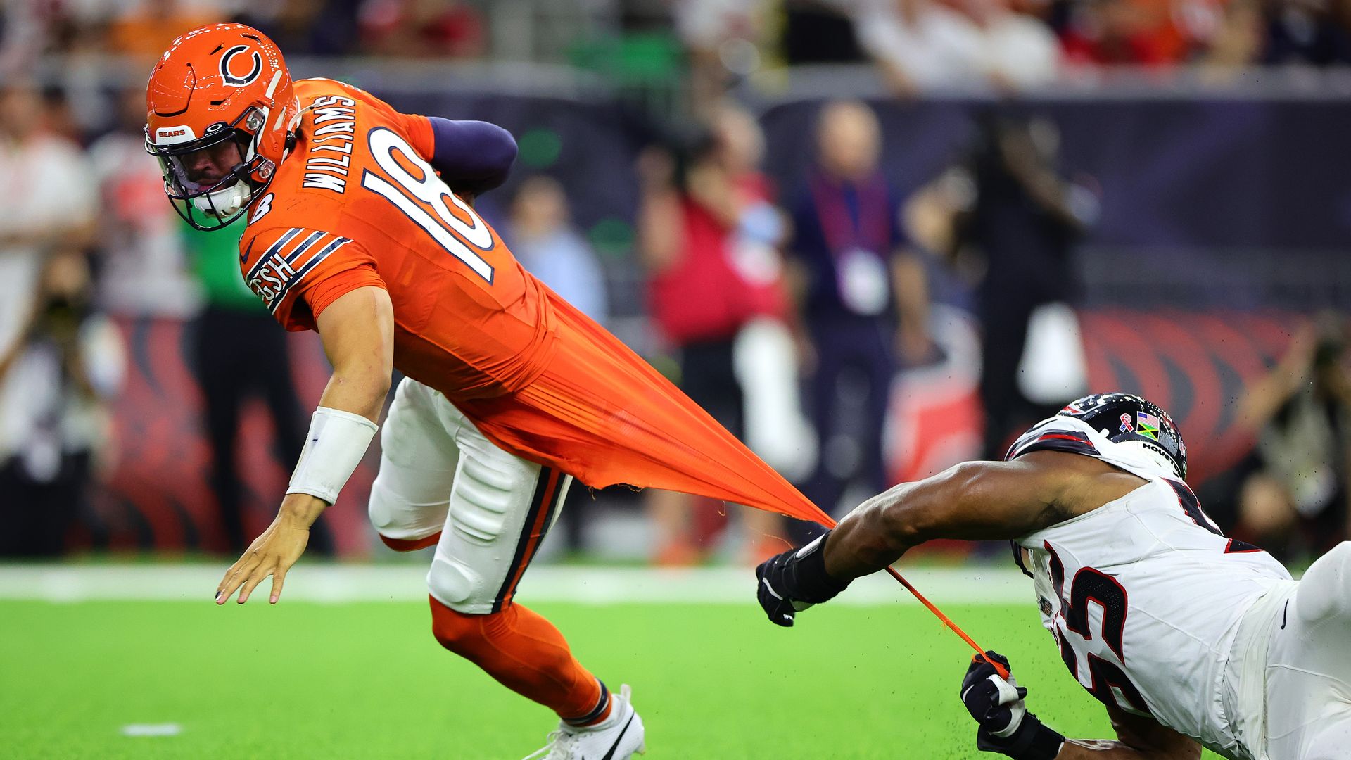 Photo of a football player grabbing the jersey of another football player on the field 