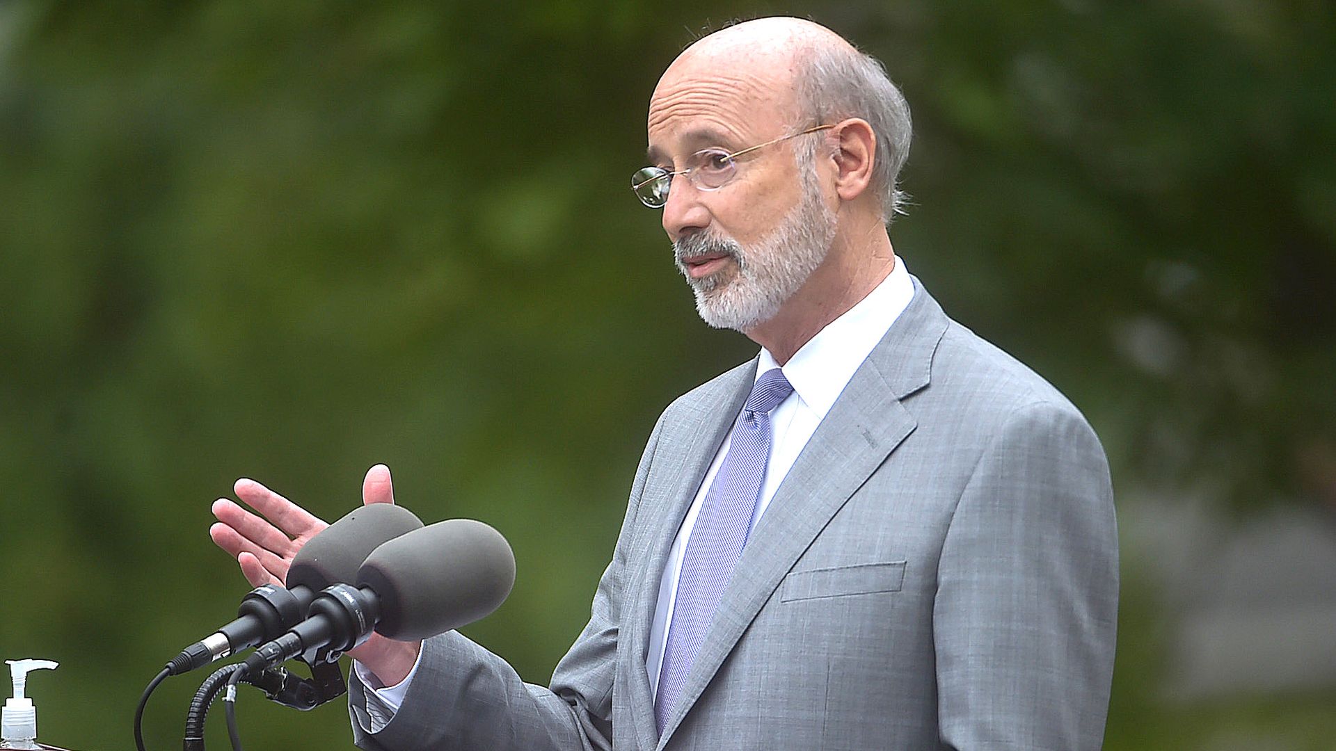 Tom Wolf stands in front of a microphone at a podium
